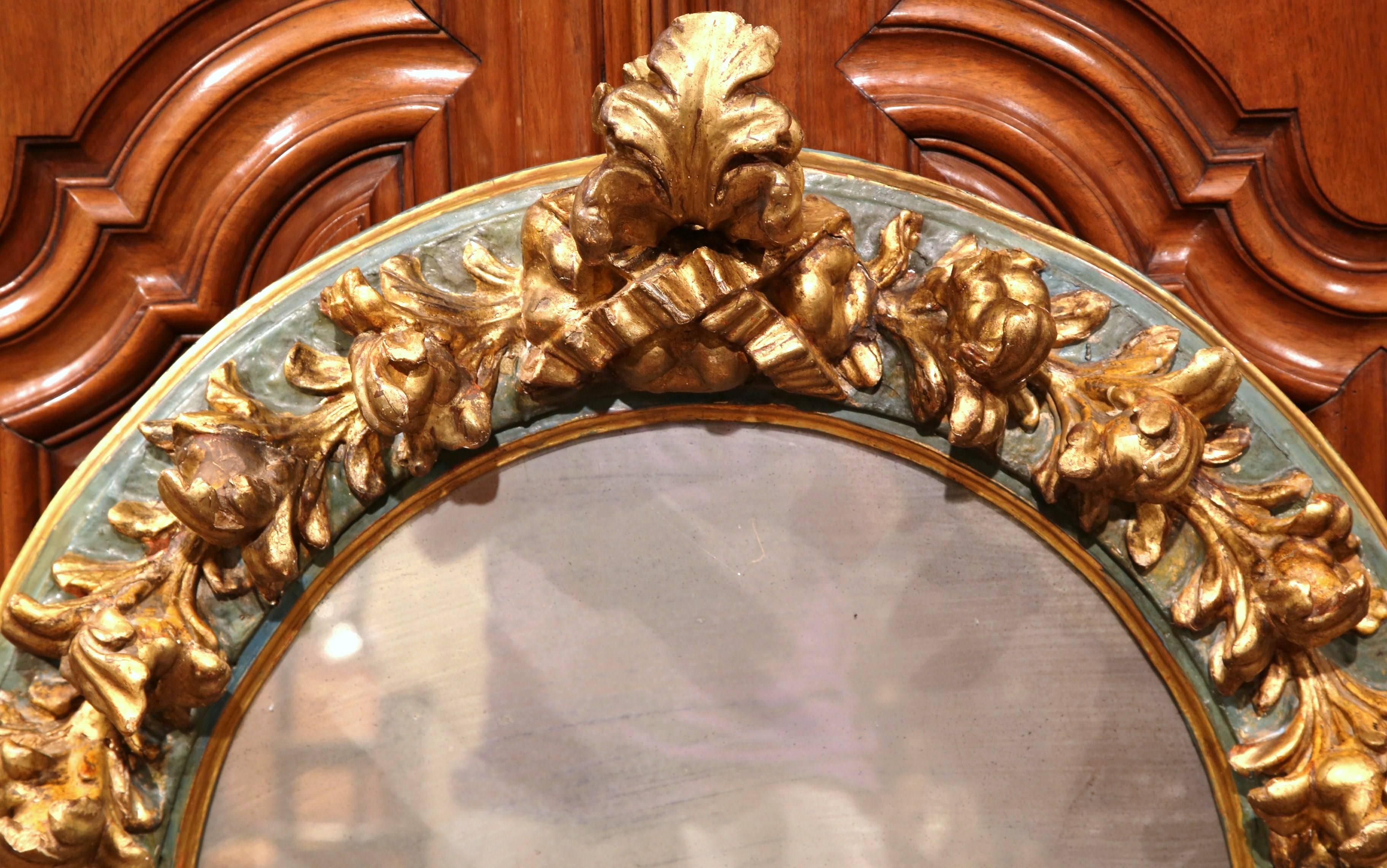 Add old world beauty into your home with this antique heavily carved mirror. Hand carved in Spain, circa 1850, the Baroque wall hanging mirror has an arched top and is unique in shape; around the frame are hand carved flowers and leaves decorated