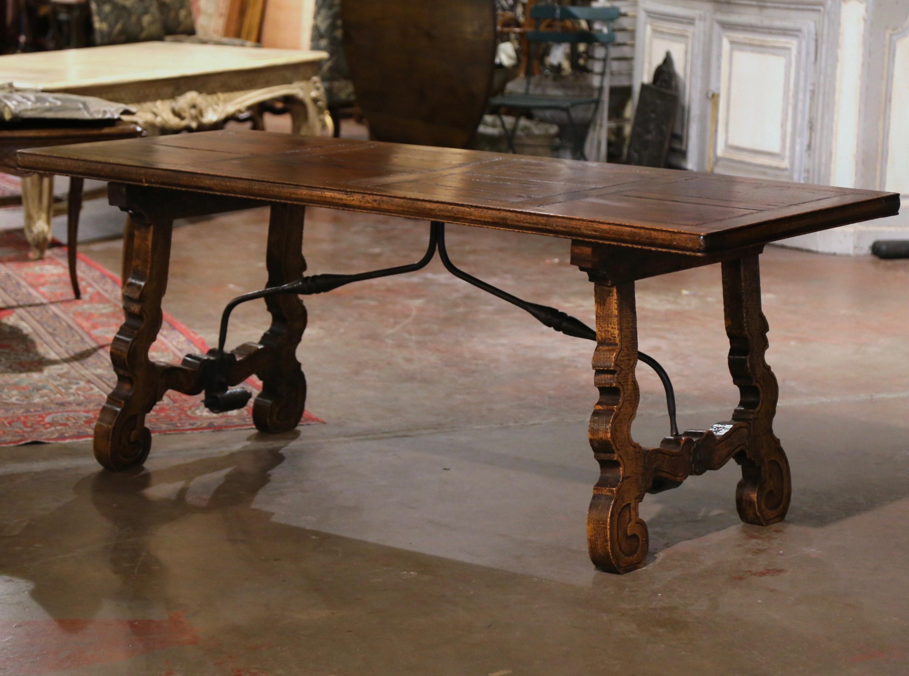 For a true Spanish look, use this elegant antique table in a dining or breakfast room. Crafted in Spain circa 1780, and built of solid chestnut and oak wood, the trestle table stands on two carved scrolled legs joined together with a forged iron