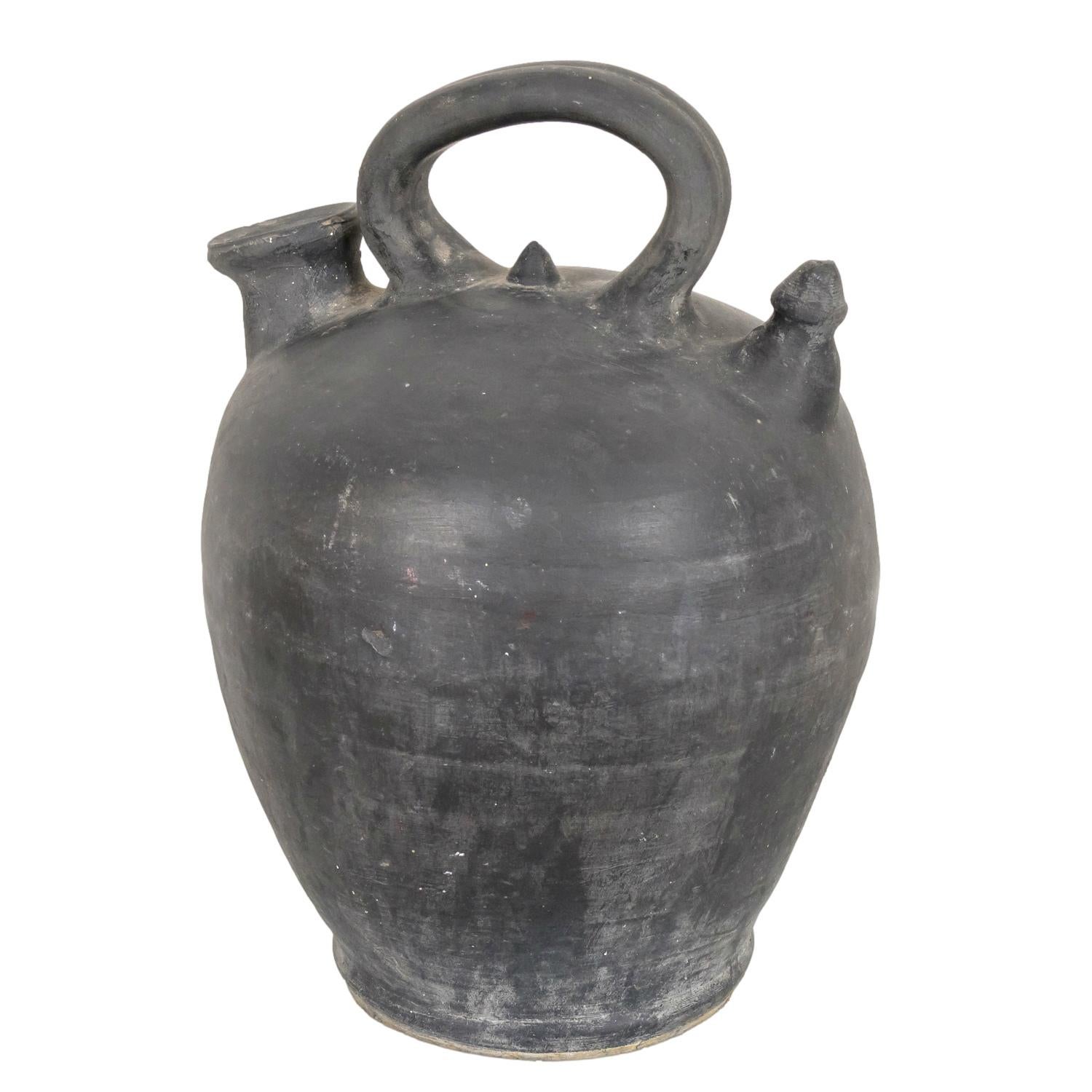 A 19th century barro negro or black clay botijo, hand made in the village of Verdú in the Catalan region of Spain, circa 1890s. This beautiful utilitarian pot, with its wide belly, top handle, and one mouth where it's filled and one mouth called a