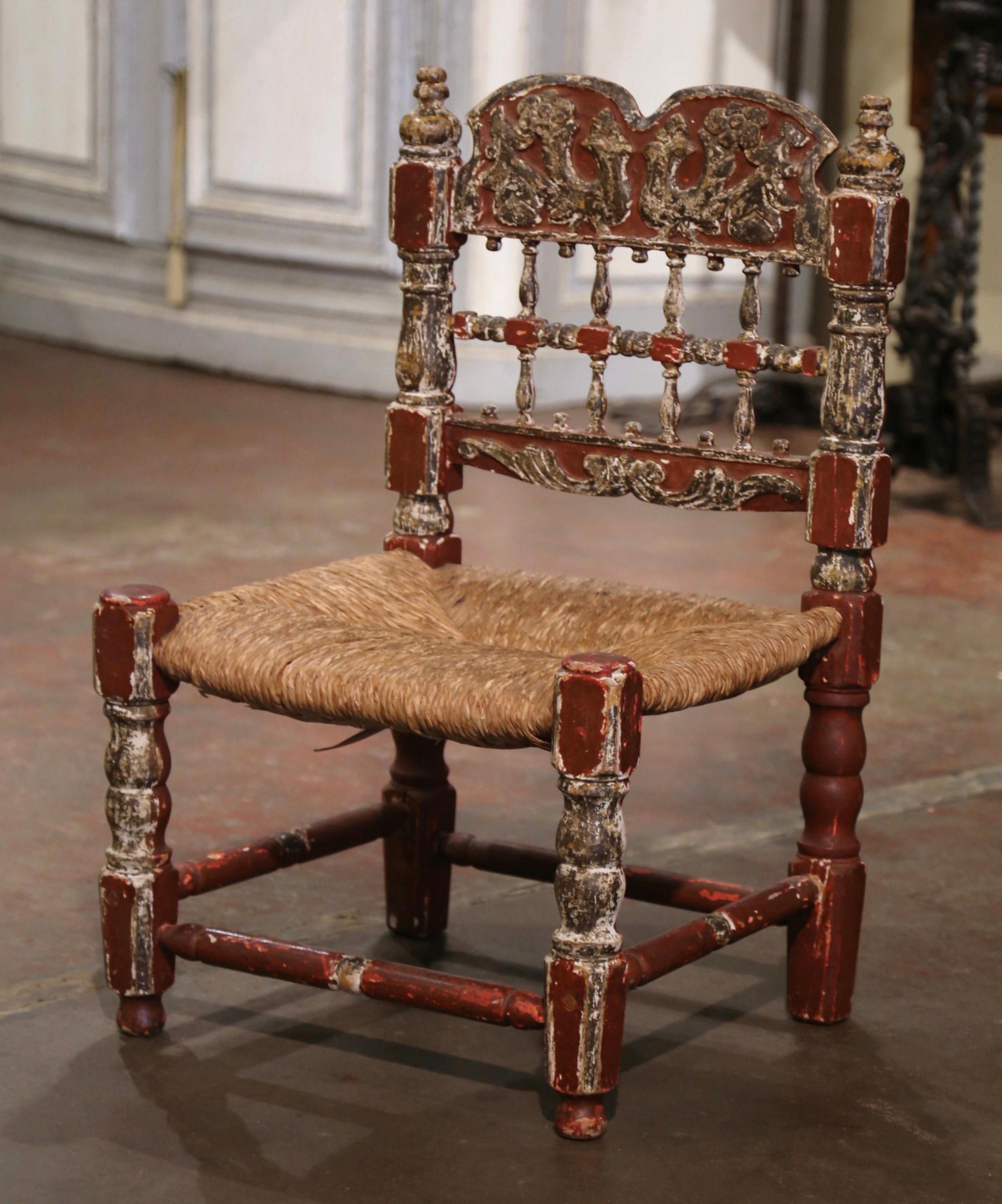 This comfortable carved chair was crafted in Spain circa 1860. Built in oak and beech wood, the chair sits on round turned legs and features an intricate back rest with floral and foliage decor; it is further embellished with round finials at the