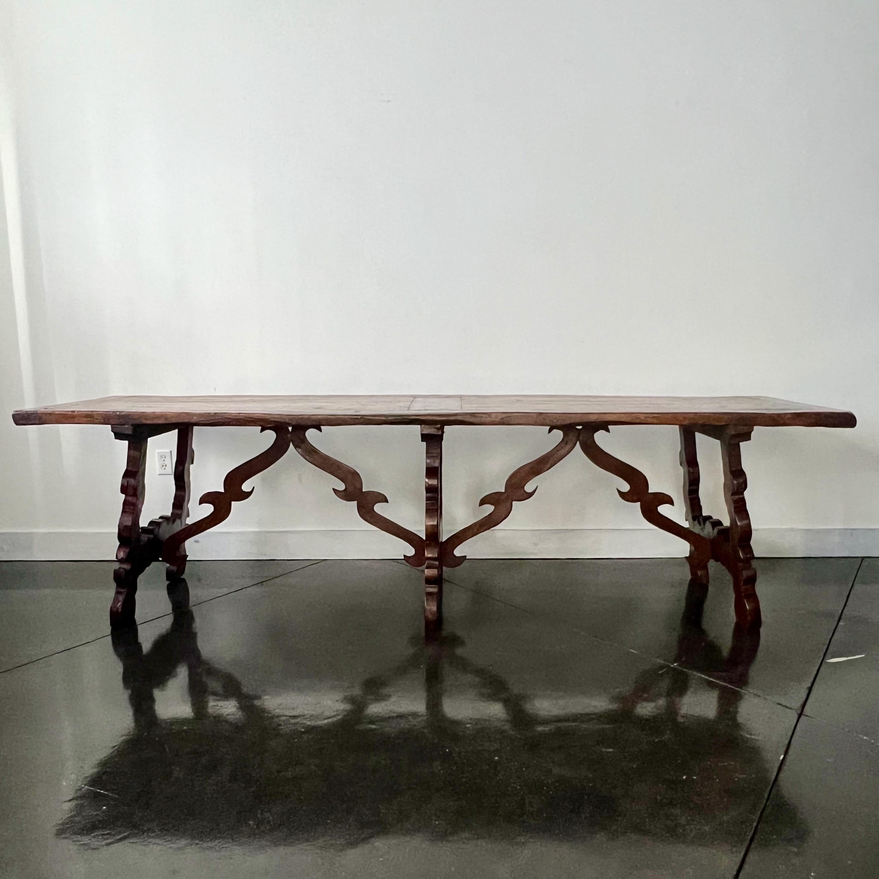 19th century Spanish Baroque style trestle table from Catalan region with framed solid walnut inset board top on three sculpted lyre legs -  joined by carved wood stretchers.
Very solid long table  - seating 10 or more depending size of chairs,