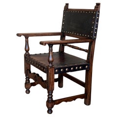 Sillón colonial español del siglo XIX tallado en forma de altar con asiento y respaldo de cuero