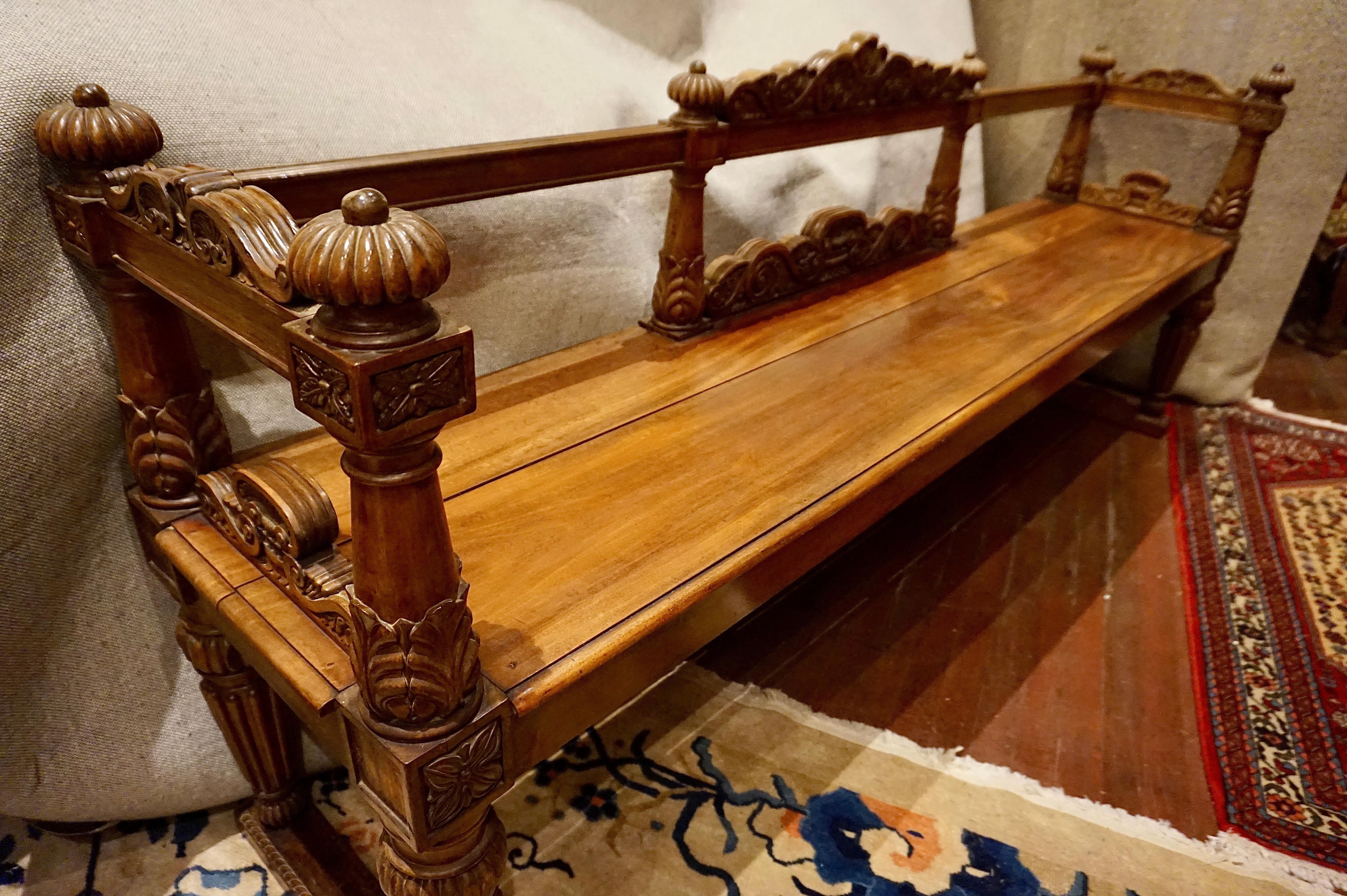 Solid mahogany carved Spanish Colonial bench that was originally from an estate in the Caribbean, circa 1850-1860. Hand carved in fine detail from mahogany. Exceptional workmanship and a design form that is rare to find in another bench with refined