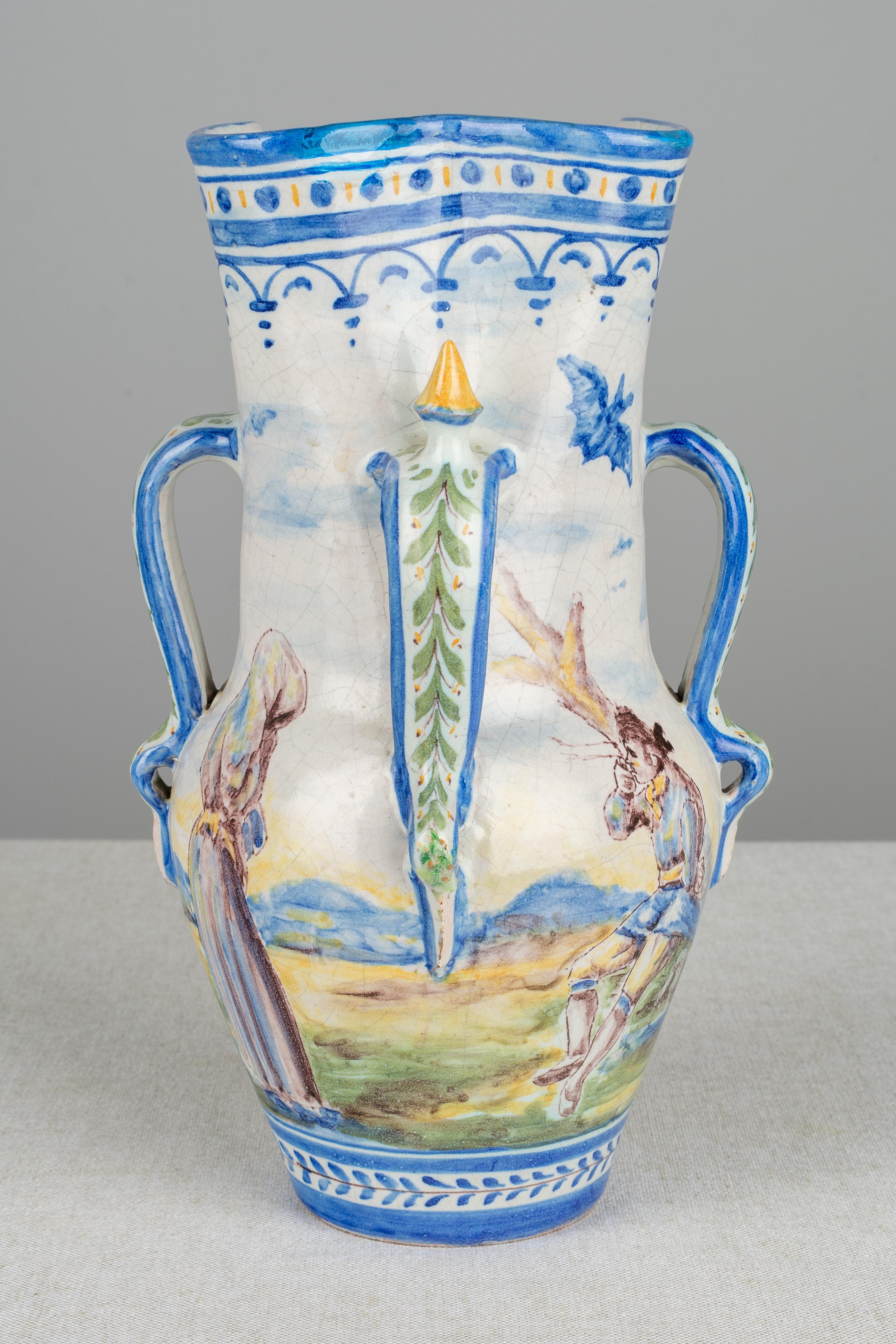 A 19th century Spanish faience vase, or pitcher with four handles. Beautifully hand painted with a central figure in a landscape setting on each of four sides with bats flying overhead. Lovely painterly quality in the depiction of the young maiden