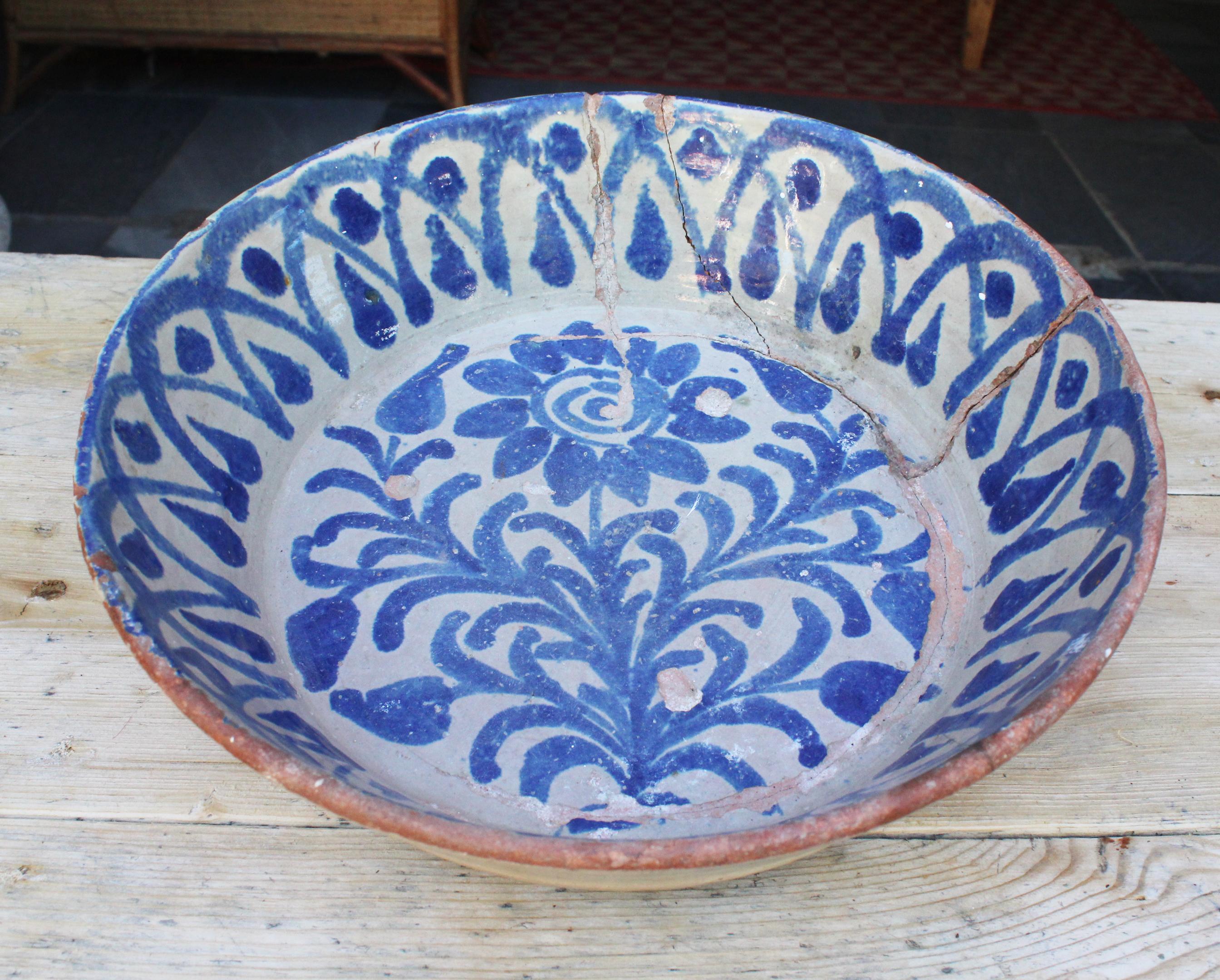 19th century Spanish Fajalauza white and blue glazed terracotta decorative plate painted with flowers. 

Fajalauza is a style that originates in Granada's Albaicín suburb, known for its mix of Christian and Al-Andalus cultures, as can be admired