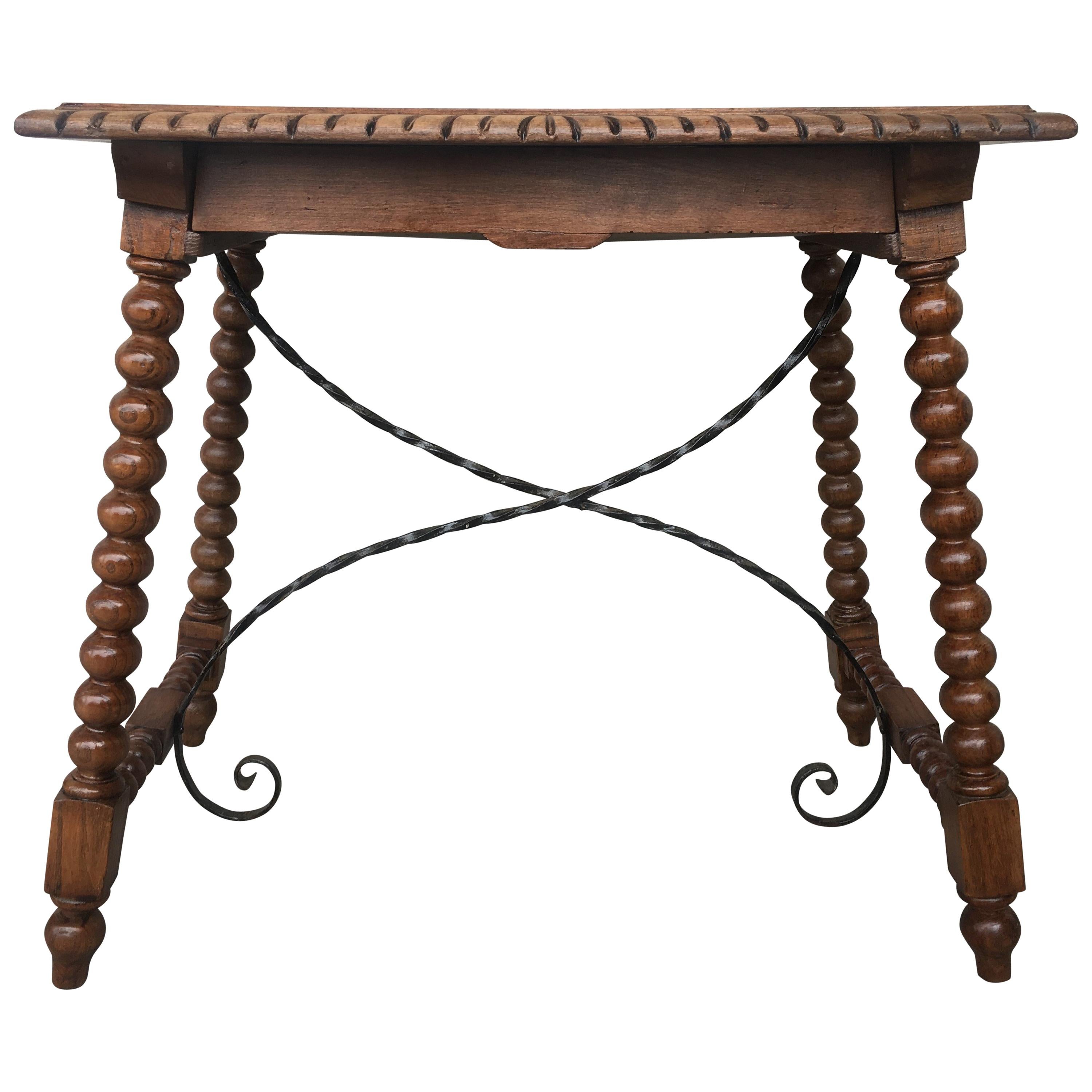 19th century Spanish farm table with iron stretchers, hand carved top and drawer.

An unusual form with nice shiny patina. Nice size for a side or end table, or as a lamp table. Graceful carved supports with a shaped edge on the top. The single