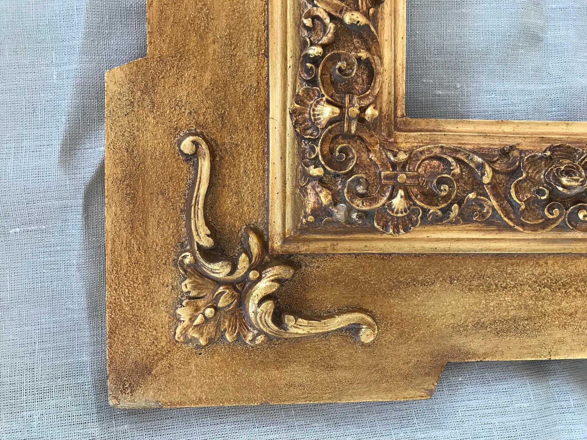 This is a carved and gilded wooden frame that presents some sizes distributed in bands. A slightly smooth outer edge already advances the predominance of the lines of the piece and towards the center an area worked with intertwined branches surround