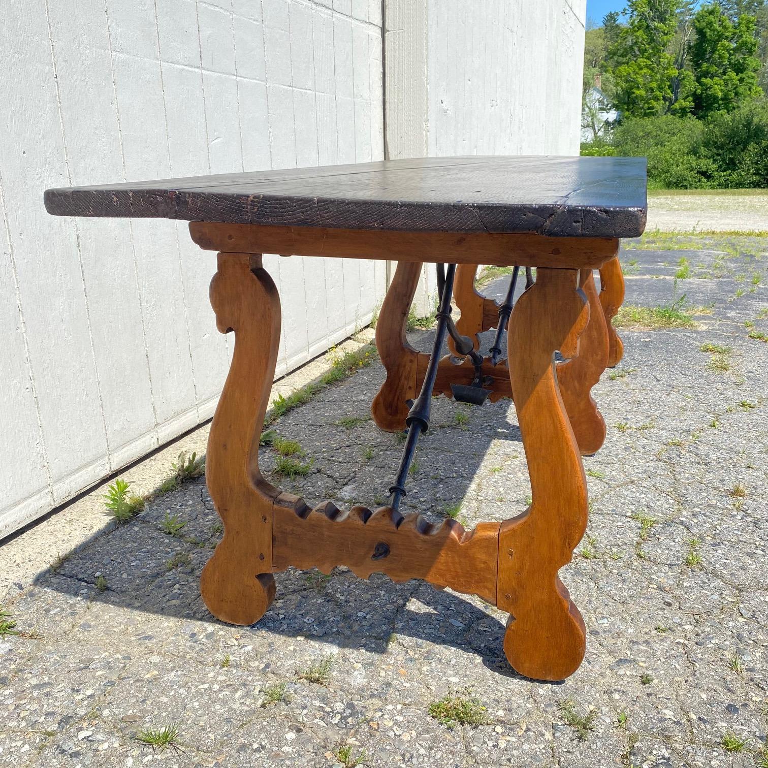 Exquise et rare table à usages multiples en chêne massif colonial espagnol du début du 19e siècle, à pieds lyre et fer, avec un superbe plateau à une seule planche, une belle base à trois pieds lyre sculptés, surmontée de brancards sculpturaux en