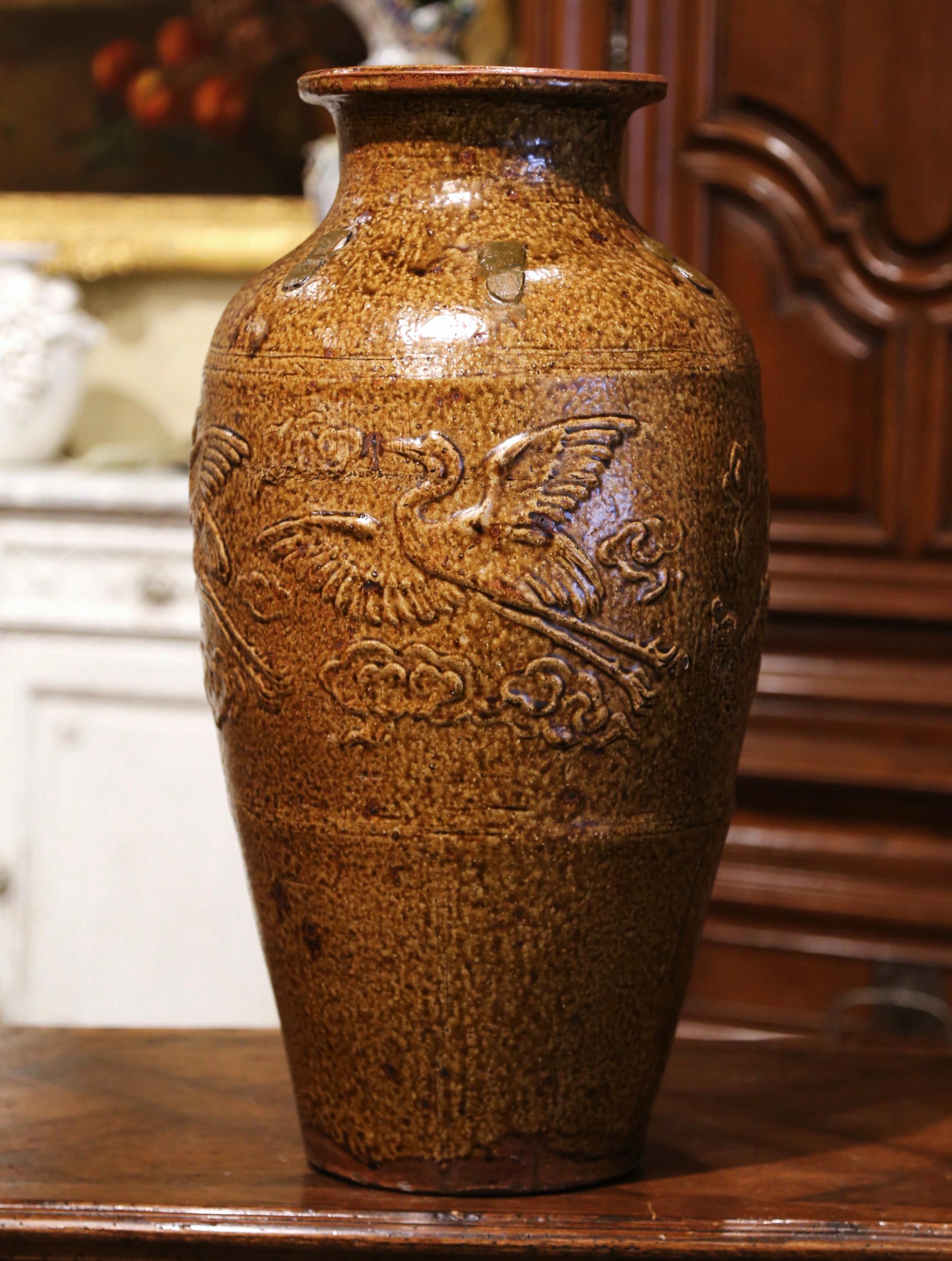 Décorez les armoires de cuisine avec ce grand pot d'huile d'olive en poterie ancienne. Créée en Espagne vers 1880 et fabriquée en terre cuite, la jarre est de forme ronde et décorée de motifs d'oiseaux en haut relief. Le grand pot est en excellent