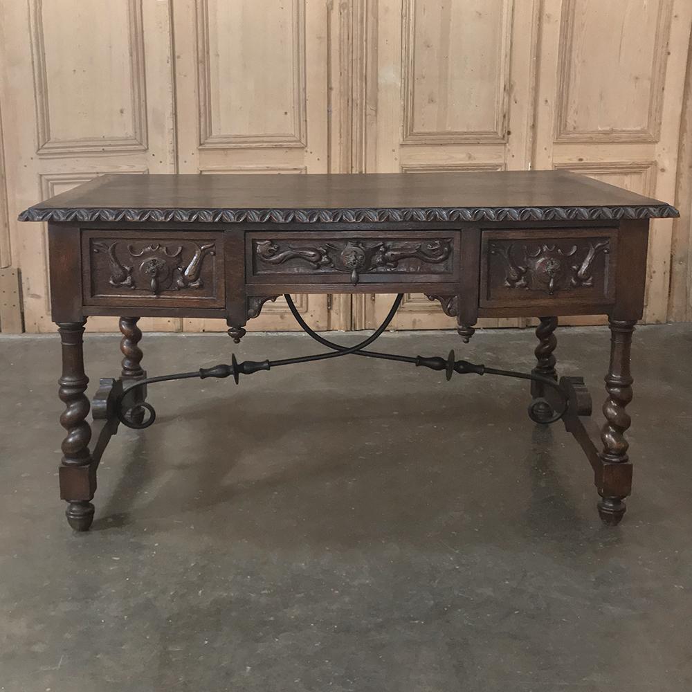 19th century Spanish writing desk features the Classic bandsawn barley twist legs connected with scrolled hand forged wrought iron stretchers. Three drawers add a functional aspect, with carved crest, dragon and foliate motifs adding to the allure.
