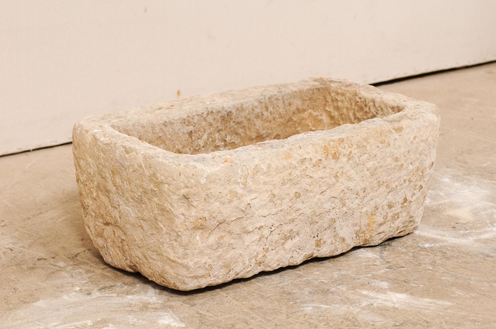A Spanish stone trough from the 19th century. This antique rectangular-shaped trough from Spain has been carved out of a single piece of stone. It is both beautiful and rustic, simplistic in design. A delightful element to enhance any landscape.