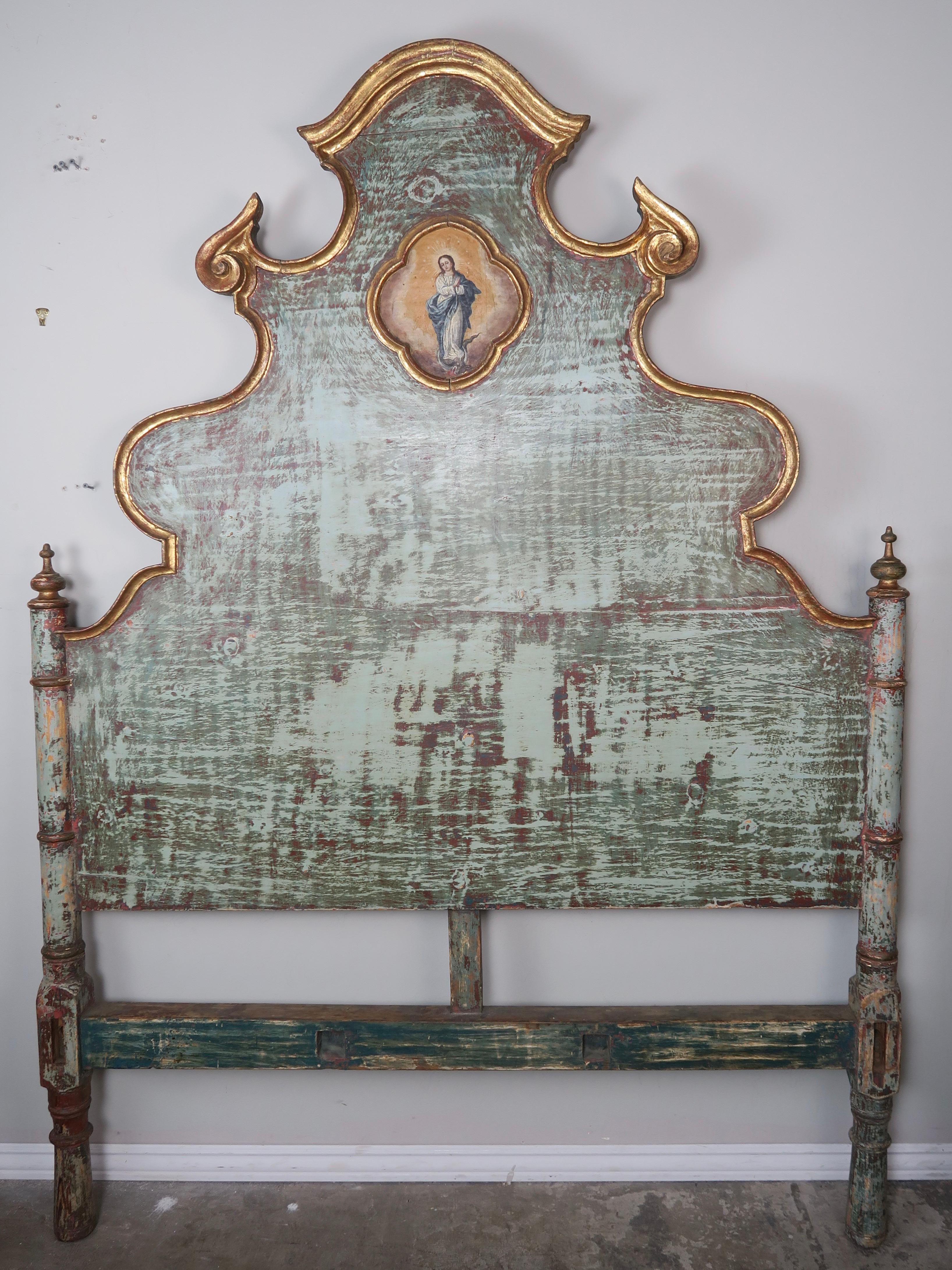 19th century Spanish painted headboard with 22-karat gold leaf detailing on the beautifully scalloped shaped frame A center cartouche depicts a fine painting of the Virgin Mary. Worn green painted finish with soft shades of aqua underneath. Absolute