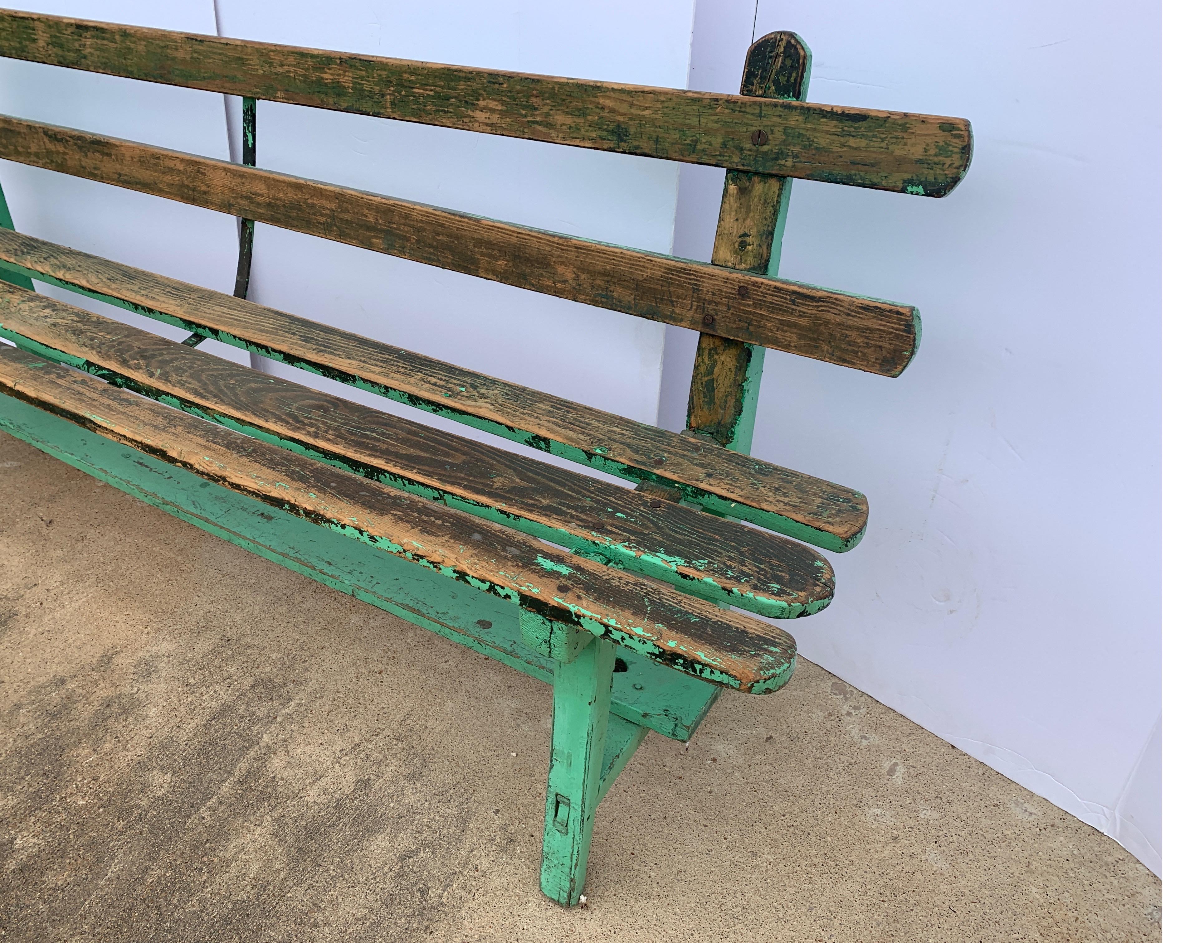 This bench is a great slat back garden bench from Spain with green paint remnants. It’s structurally sound and perfectly rustic.