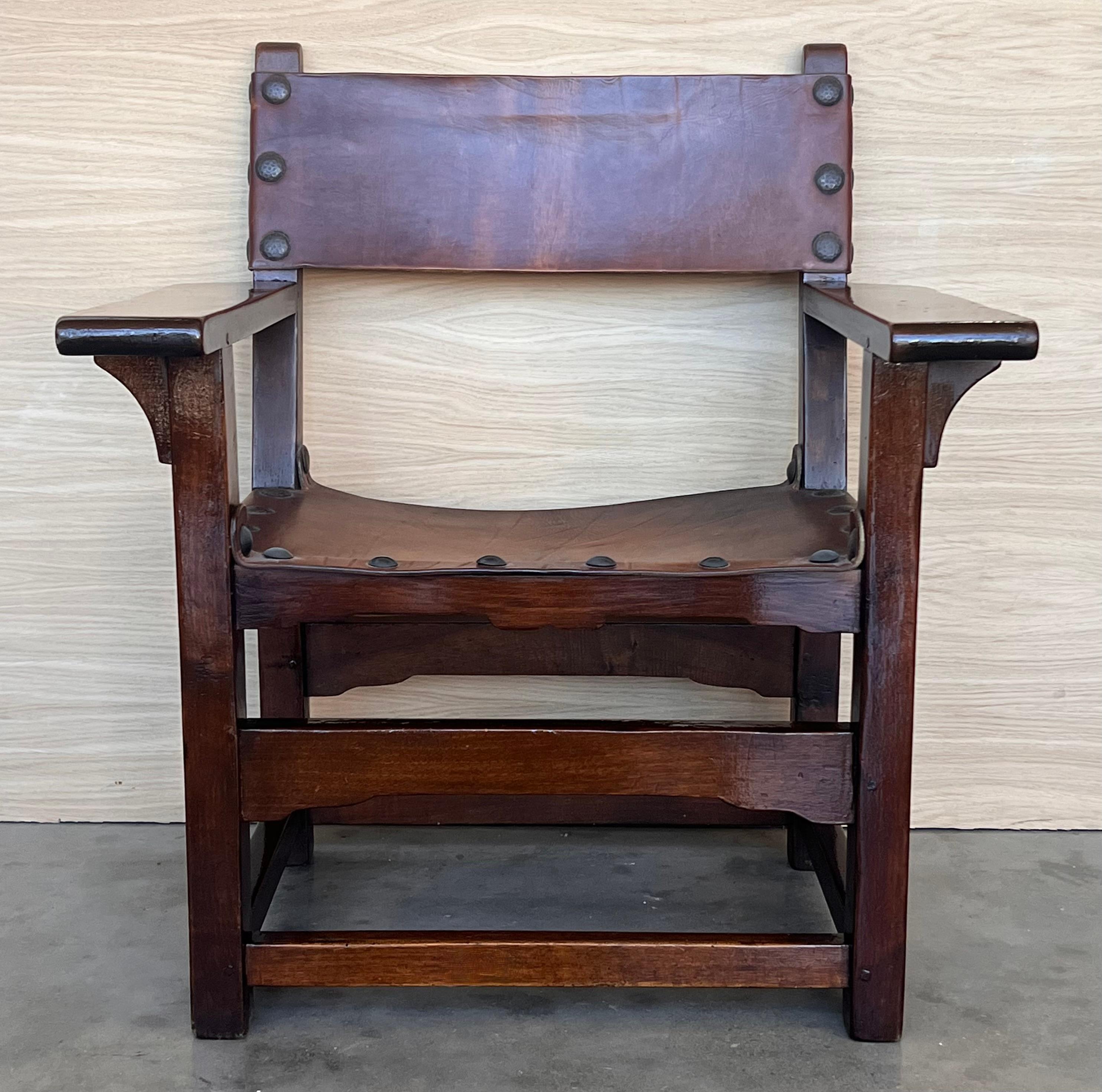 19th century walnut Spanish colonial altar armchairs with leather back and seat The unusual size of the arms complete this exceptional pair of armchairs
Measures: Height to arms 23.81 in.