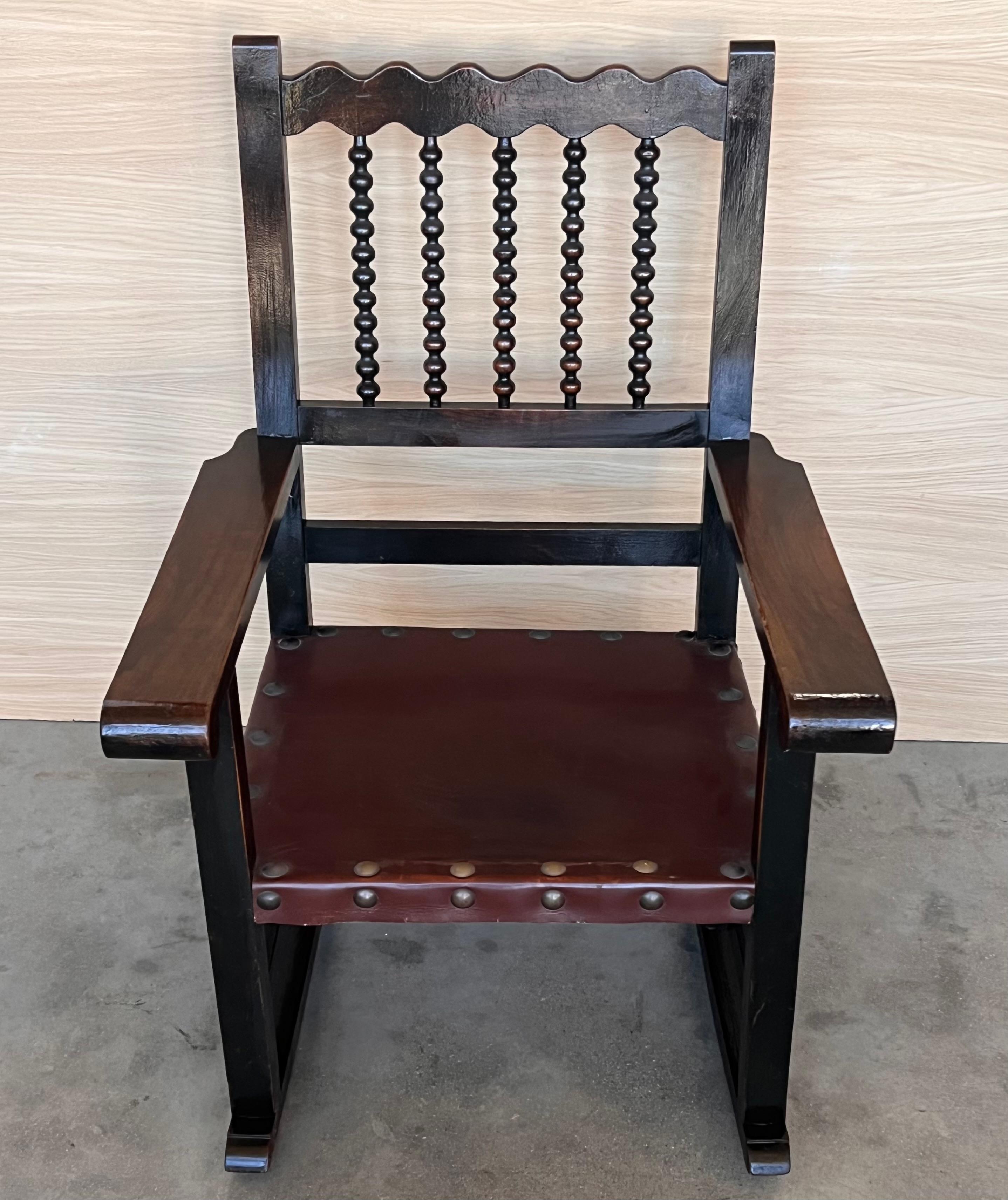 Balançoire espagnole en noyer du 19e siècle  fauteuils avec dossier en barre et assise en cuir 
Mesures : Hauteur aux bras 24.40 in.