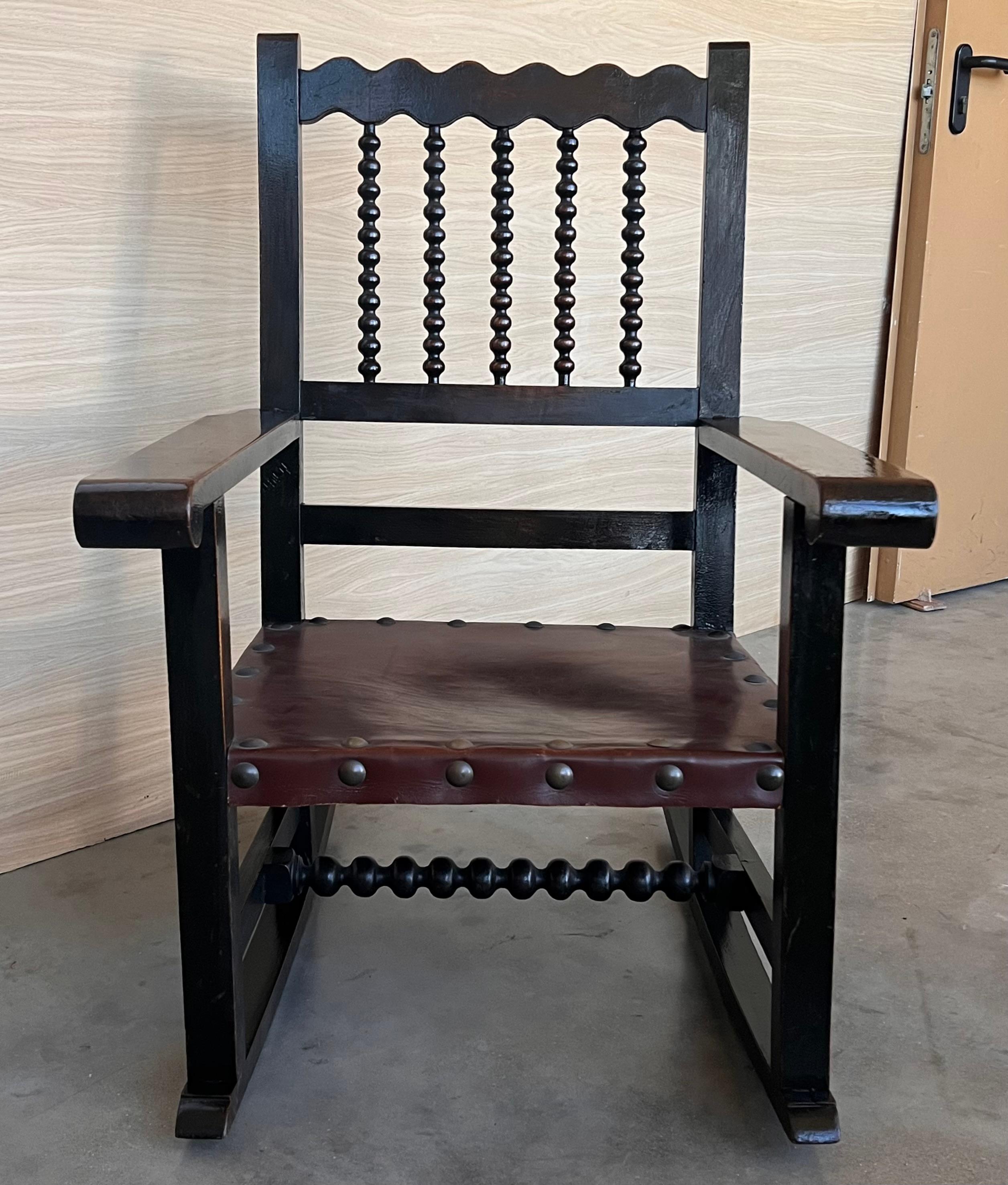 Colonial espagnol Paire de fauteuils espagnol du 19ème siècle sculptés à bascule avec assise et dossier en cuir en vente