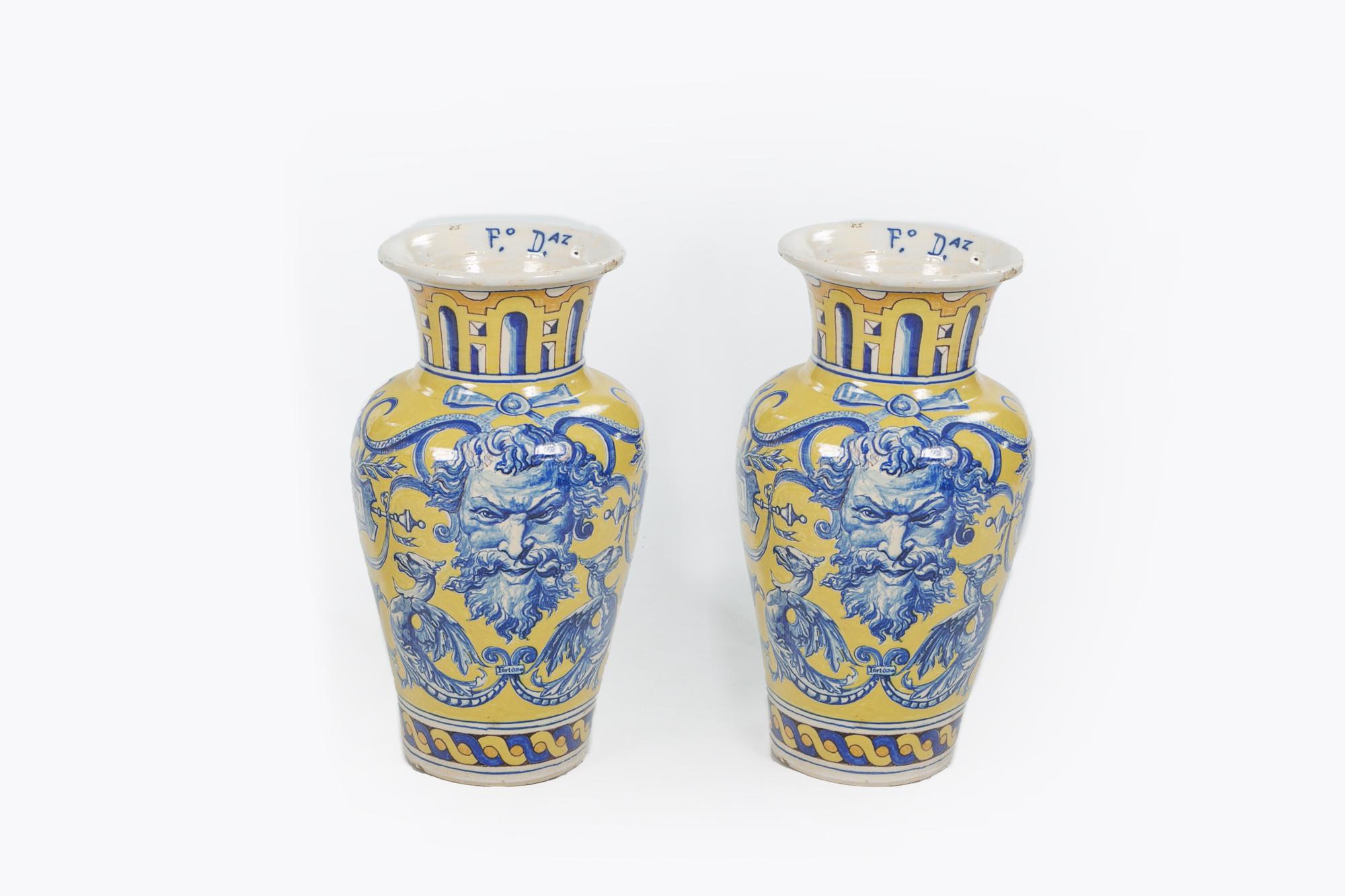 19th-century Spanish pair of large urns with blue mythical masks, dragons, scrolling acanthus leaves, linen swags and with printed text: NO 8 Do, BETTICA and Tortosa all against a yellow background, Talavera de la Reina Pottery, stamped