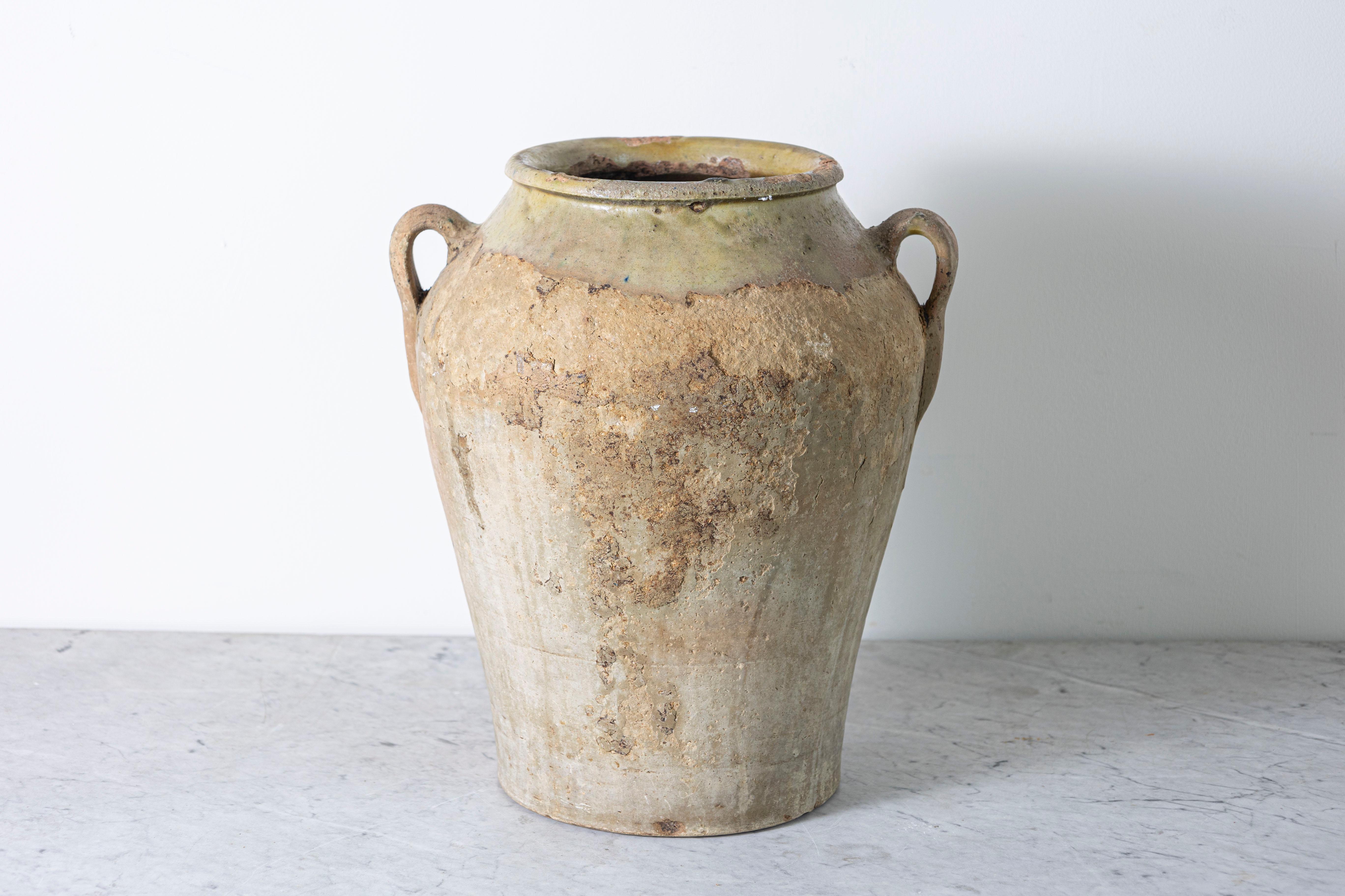 This stunning 19th-century Spanish terracotta jar exudes rustic charm and historical significance. Handcrafted with a classic amphora-inspired silhouette, it features two gracefully arched handles for both functionality and aesthetic appeal. The