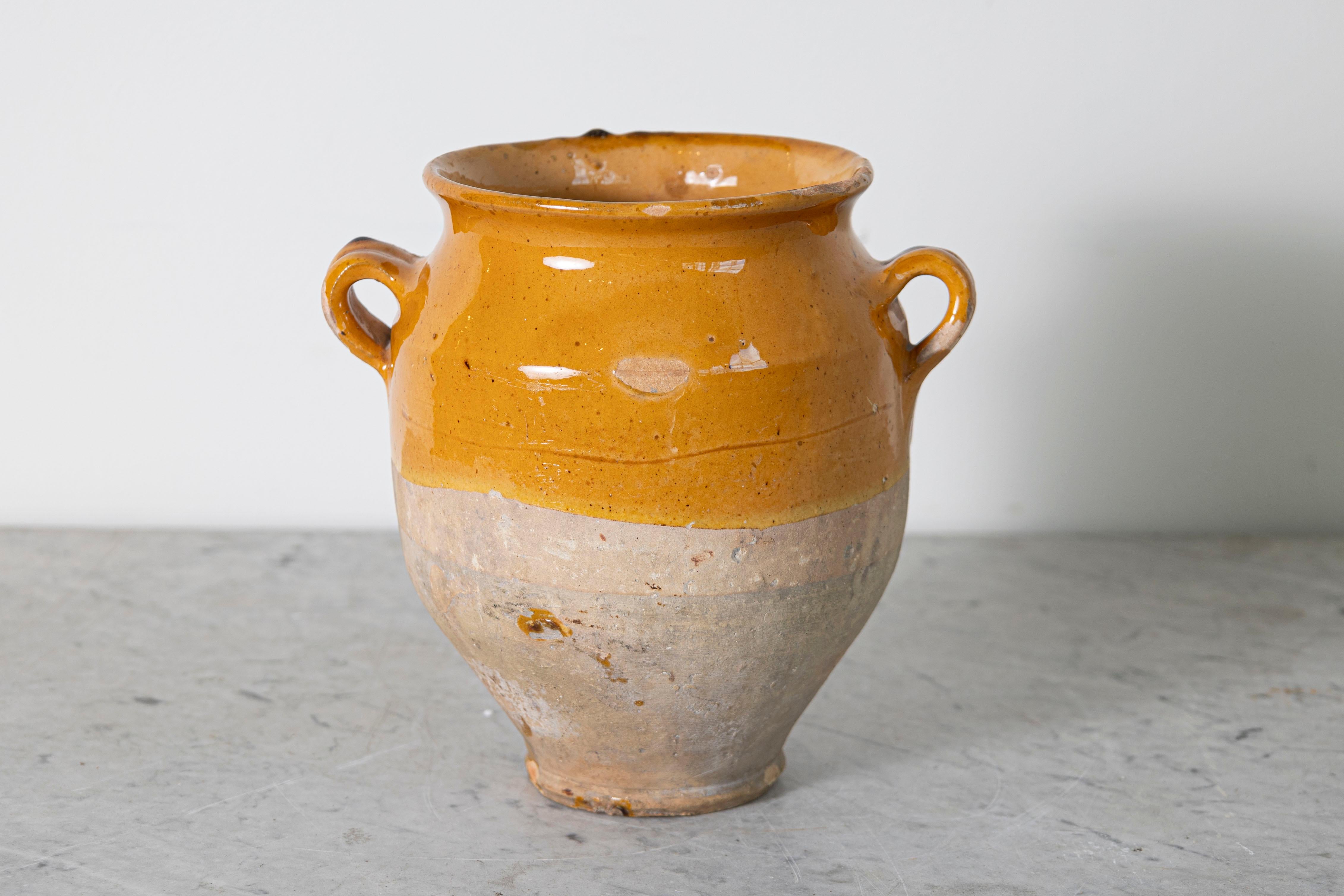 This charming 19th-century Spanish terracotta pottery jar showcases the rustic elegance of traditional ceramic craftsmanship. With its warm ochre glaze and natural earthy tones, it reflects the utilitarian yet artistic design typical of Spanish