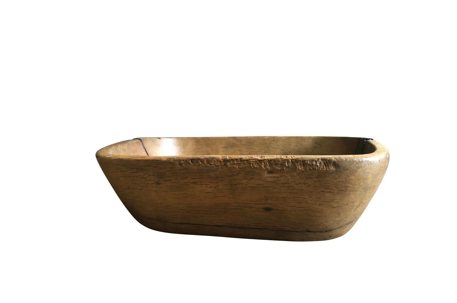 A very charming and Primitive bowl from the Catalan region of Spain. Hand carved from a single trunk of oak with a wonderful old repair in metal. A beautiful kitchen island or tabletop accessory.