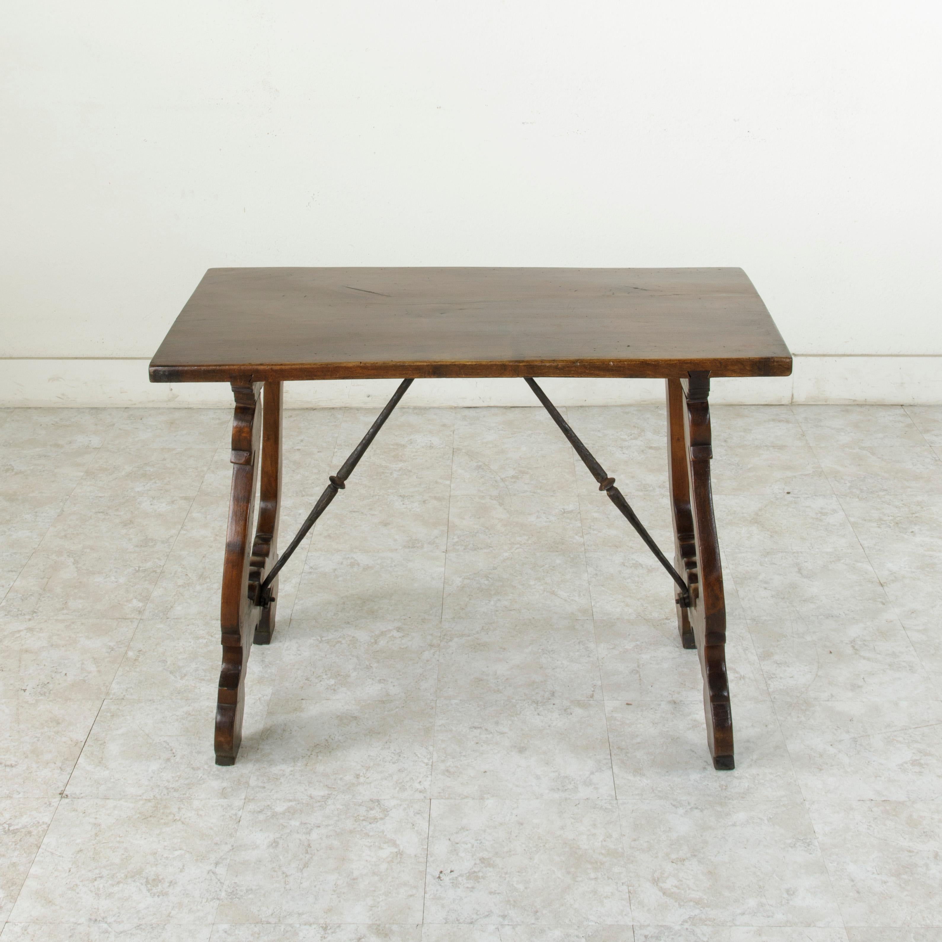 This small scale mid-19th century Spanish Renaissance style table features a 21-inch wide walnut top made from a single plank of wood. The top is joined to its elegantly curved legs by means of two splines that run the entire width of the table.