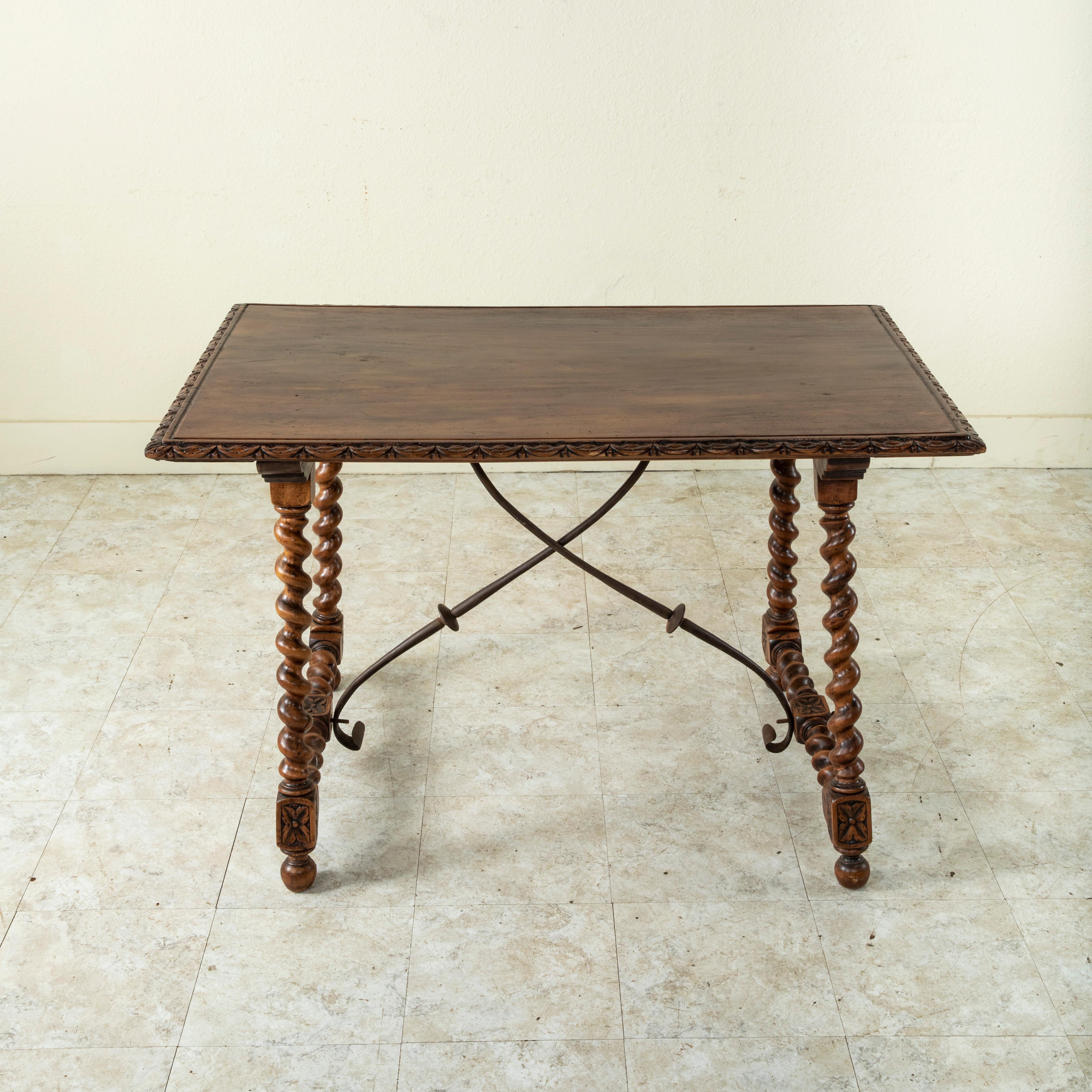 This late nineteenth century walnut table from France features a hand-carved beveled top made from a single piece of wood, and rests on classic barley twist legs. Barley twist stretchers are joined to the legs at the hand pegged lower die joints,