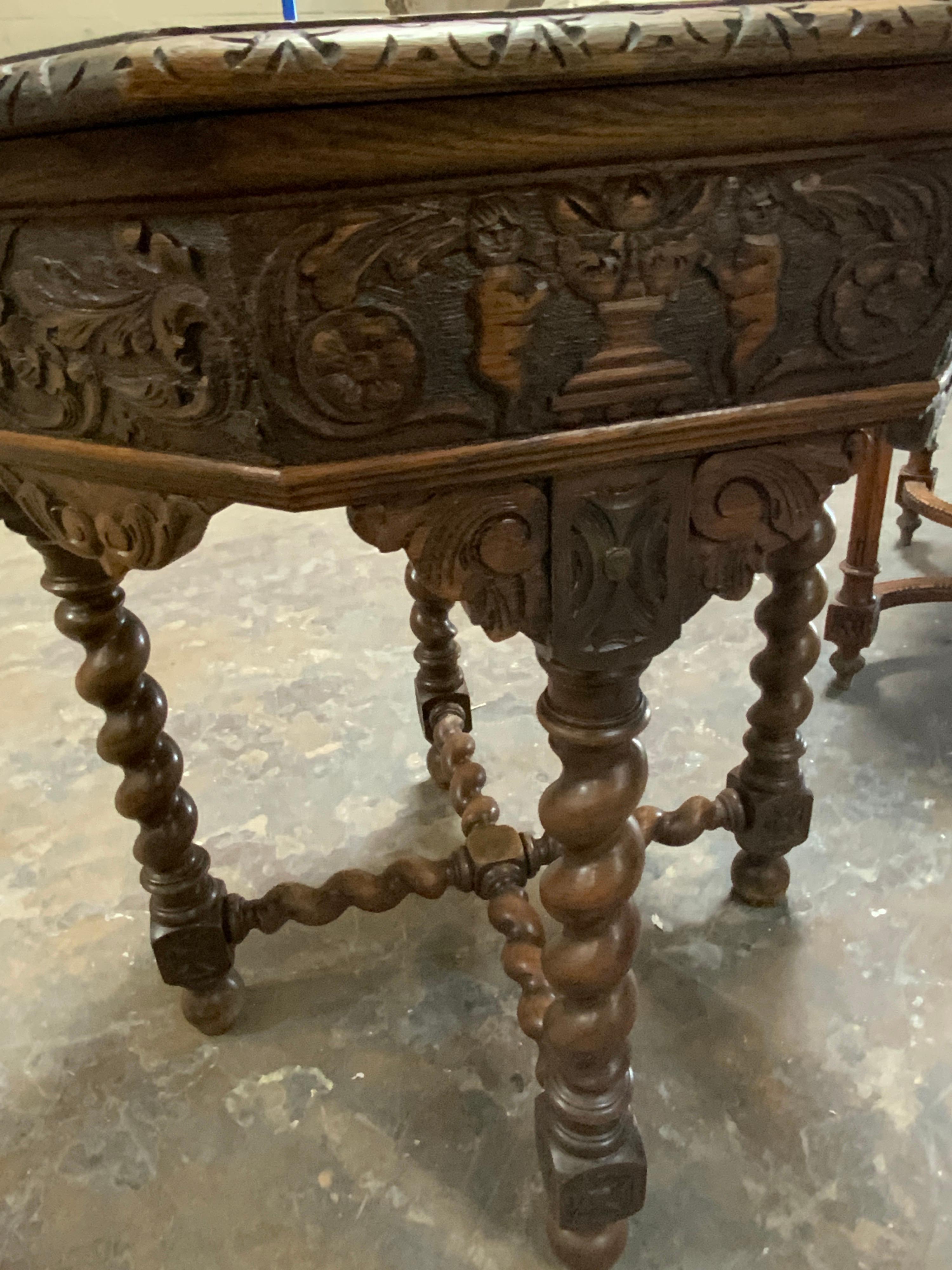This hand-carved oak table features an octagonal surface with intricate design along the edge. Origin Spain.