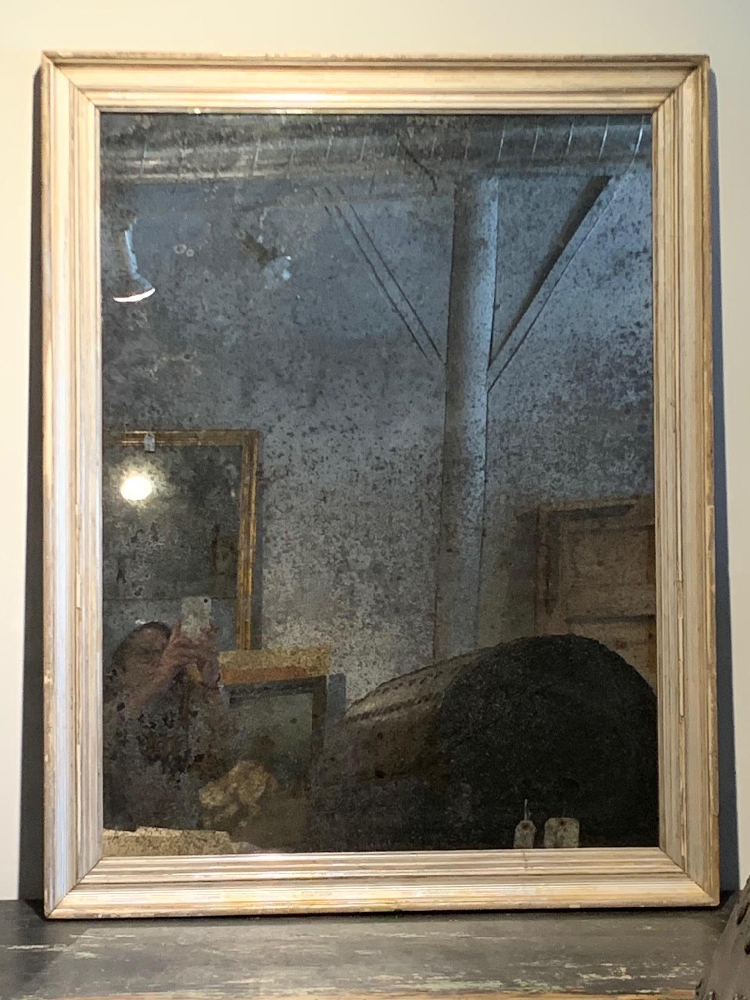 A very lovely 19th century silver giltwood frame now as a mirror. The glass is nicely crazed. To hang either horizontally or vertically. Wonderful size for a powder room or a bathroom, or as an over mantel mirror. Beautiful patina.