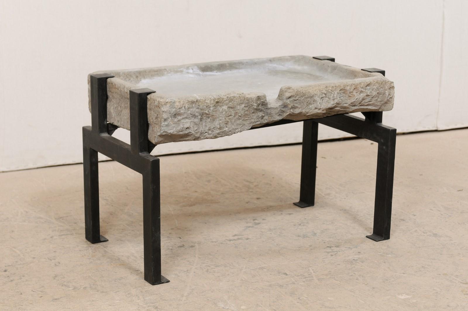A 19th century Spanish stone trough top coffee table. This smaller-sized table has been custom fashioned from a 19th century Spanish stone trough, having an overall rectangular-shape, and drain spout located at one longer side. The trough has been