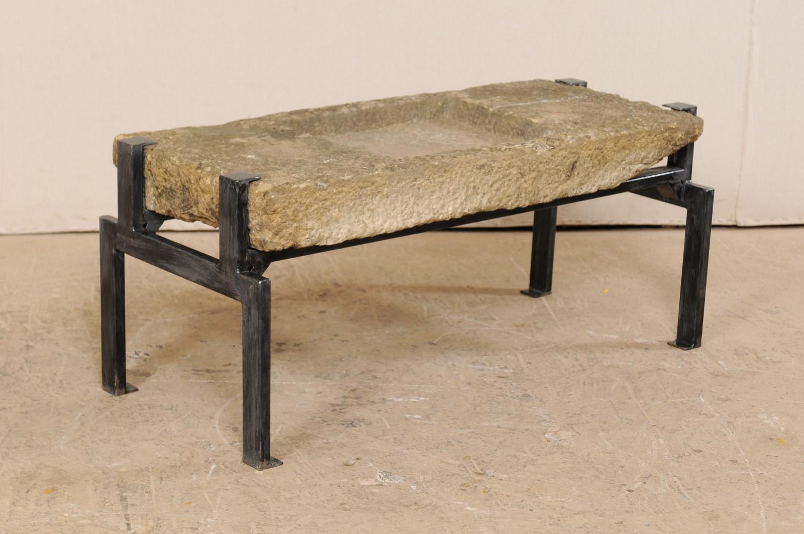 A 19th century Spanish stone trough top coffee table. This unique table has been custom fashioned from a 19th century (though potentially older) Spanish stone trough, having an overall rectangular-shape, and shallow squared basin, with small drain