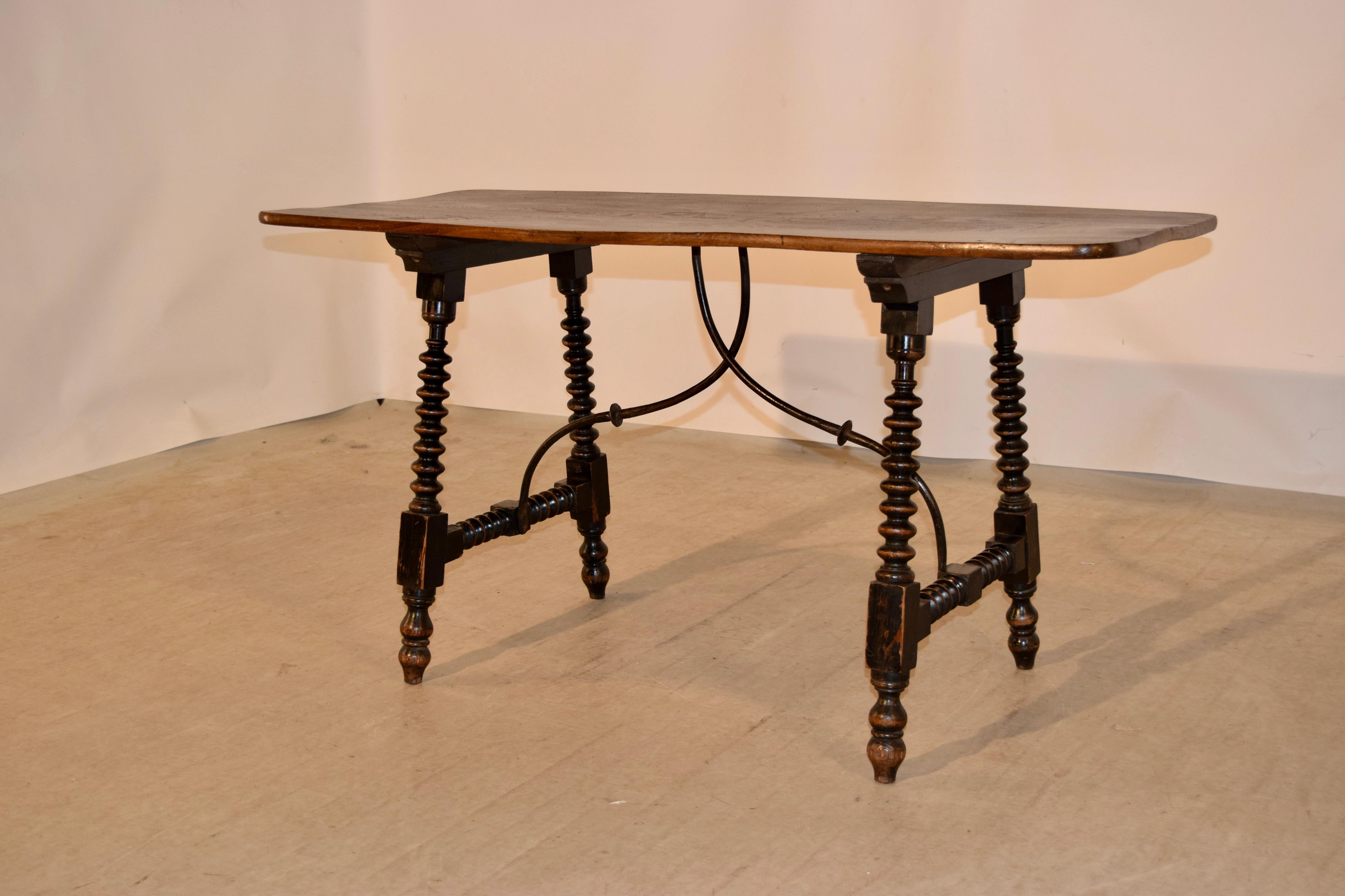 19th century table made from walnut and elm. The top is wonderfully grained curly elm, following down to a base made from walnut with a nicely turned spool shaped legs, joined by matching stretchers and braced together in the centre of the table