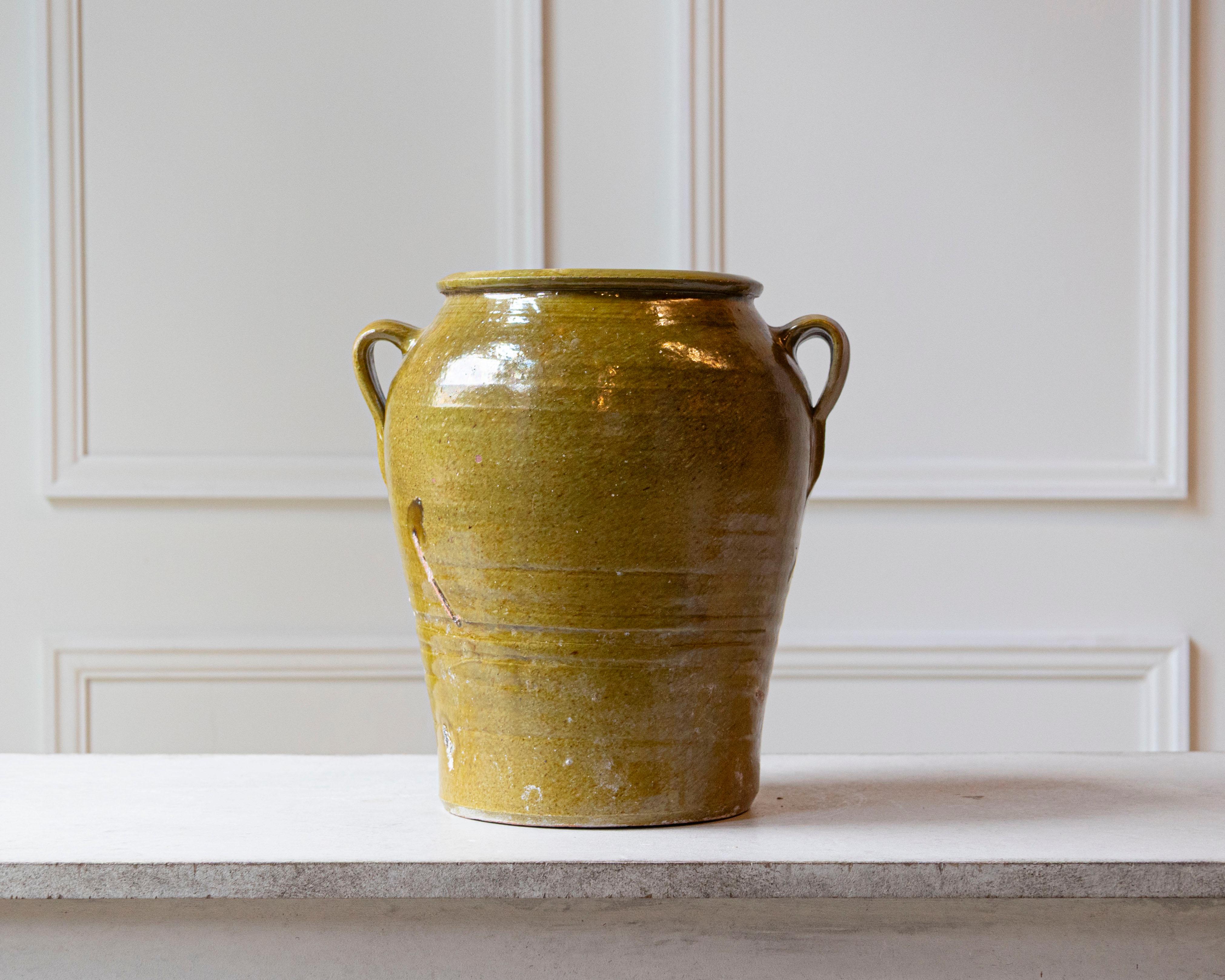 This 19th-century Spanish terracotta jar embodies rustic charm and timeless beautiful Mediterranean craftsmanship. Hand-thrown from clay, the vessel is distinguished by its rich green glaze, a color often associated with Spanish country pottery. The