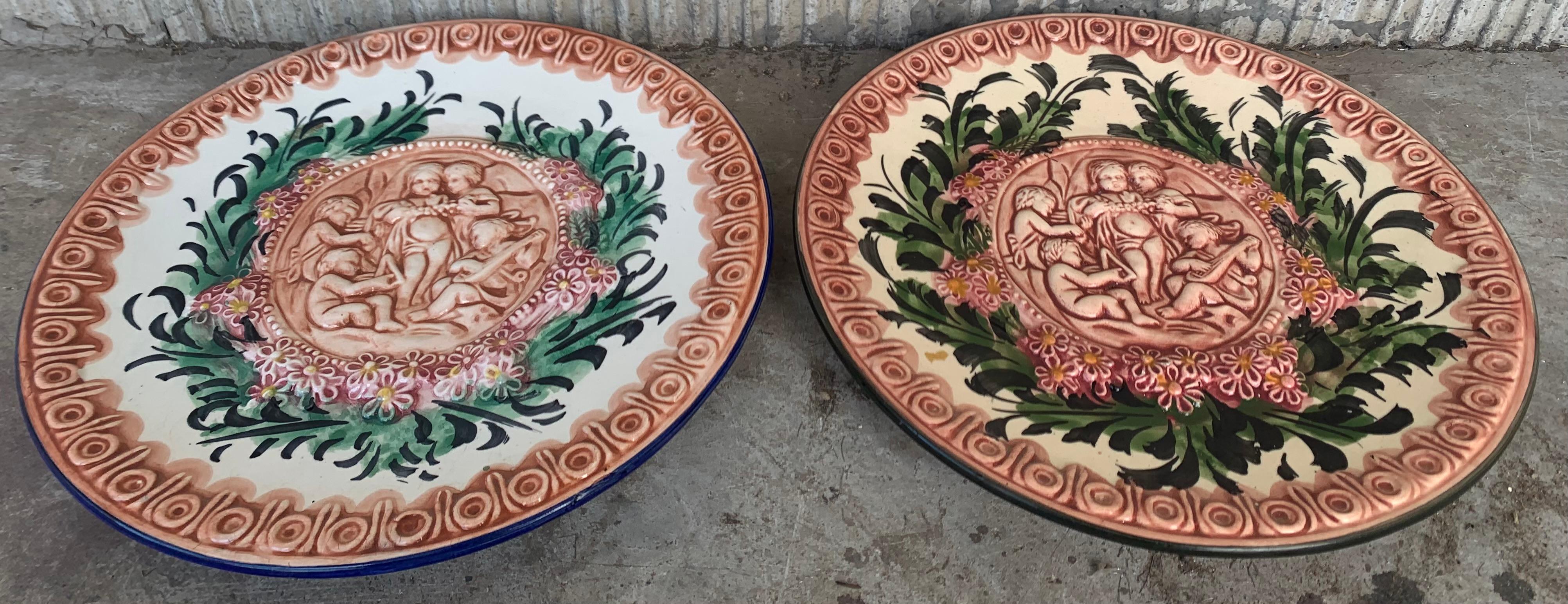 Lovely antique circular decorative porcelain platers, a round relief centered by hand repoussé children figures playing, with flowers and superlative bas relief hand chased allegorical grottesques, scrolls and flowers on the round border.
 
