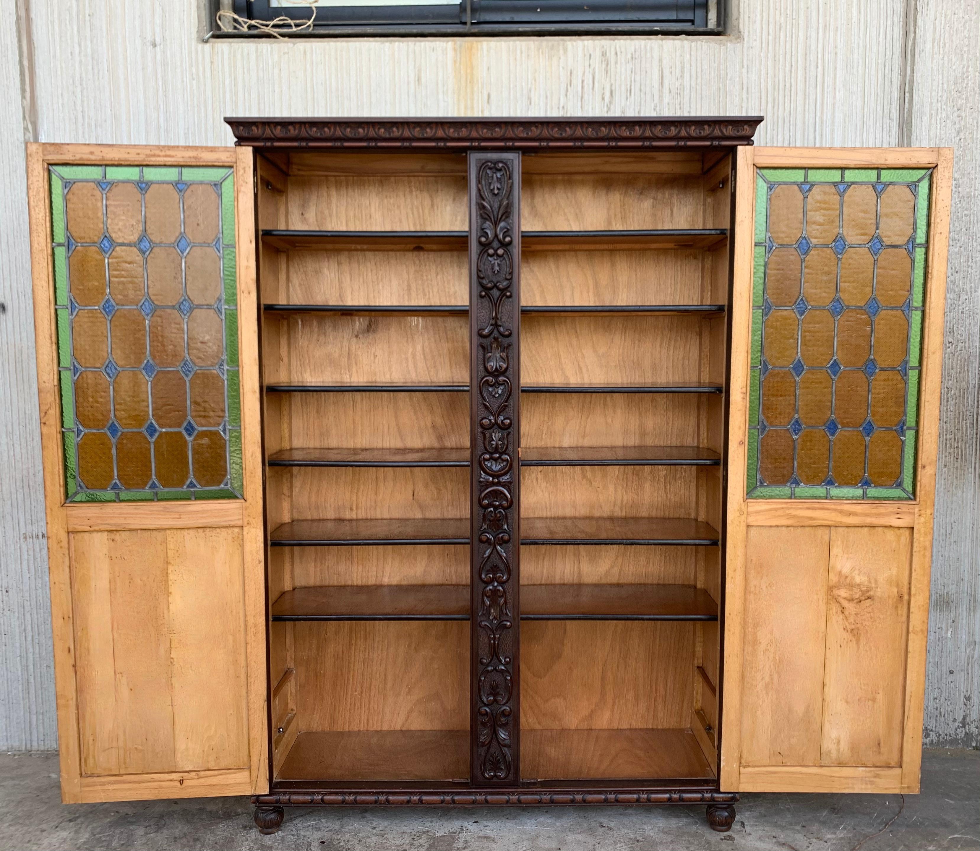 19th century Spanish walnut cabinet or bookcase can store books, heirlooms, a special collection, or any objets d'art! Glazing colored stained on the doors and on the sides ensures plenty of ambient light to showcase your items. Just the right