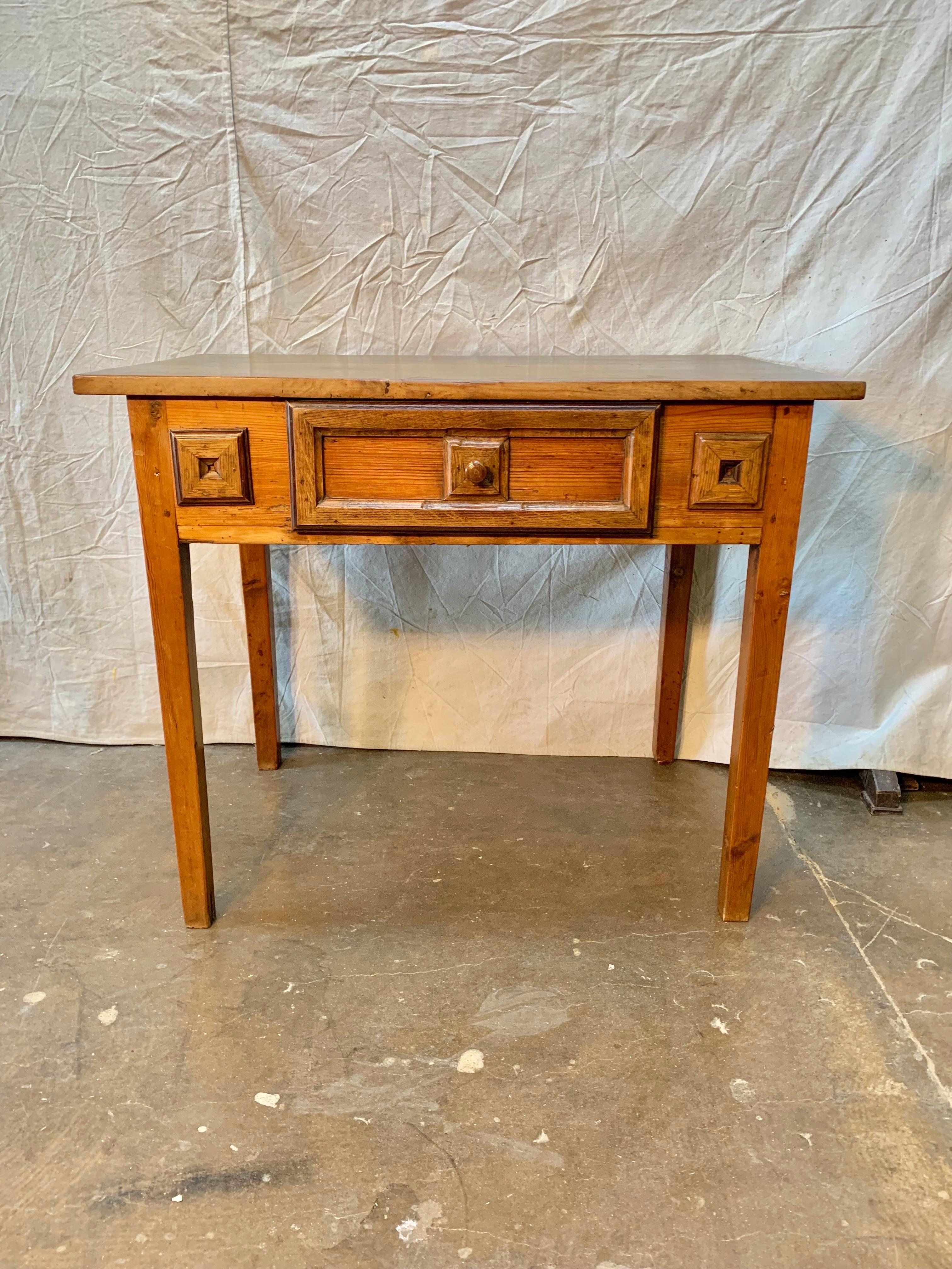 Found in Spain this 19th Century Spanish Walnut One Drawer Side Table features a rectangular top sitting above a single dovetailed drawer adorned with a wood pull which rests above four sturdy legs. The drawer and table facade are adorned with hand
