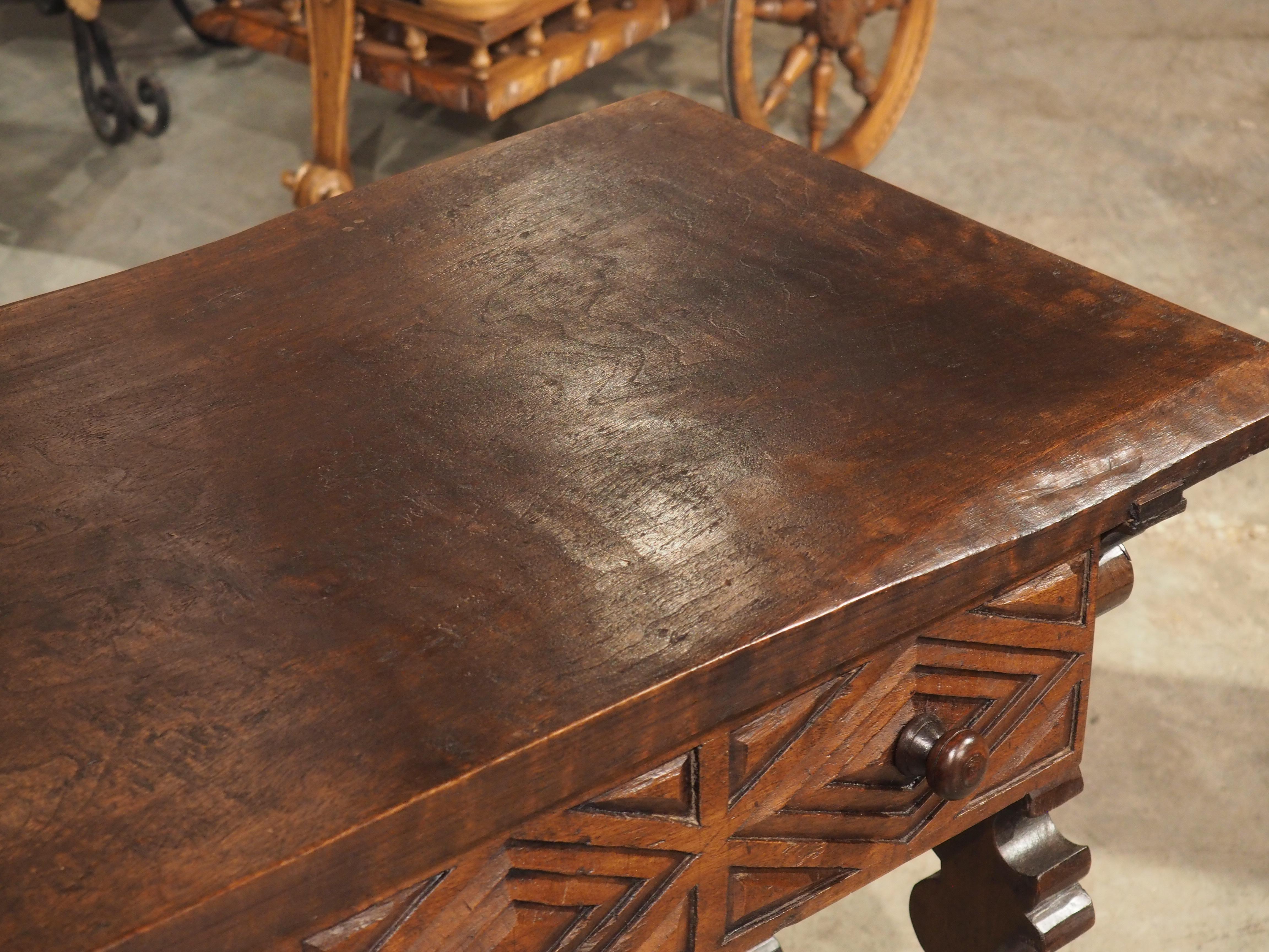 This 19th century table is the perfect addition to any room, providing both style and versatility. Crafted from walnut wood and featuring a hand-wrought iron stretcher, it captures the original appeal of Spanish designs from previous centuries, but