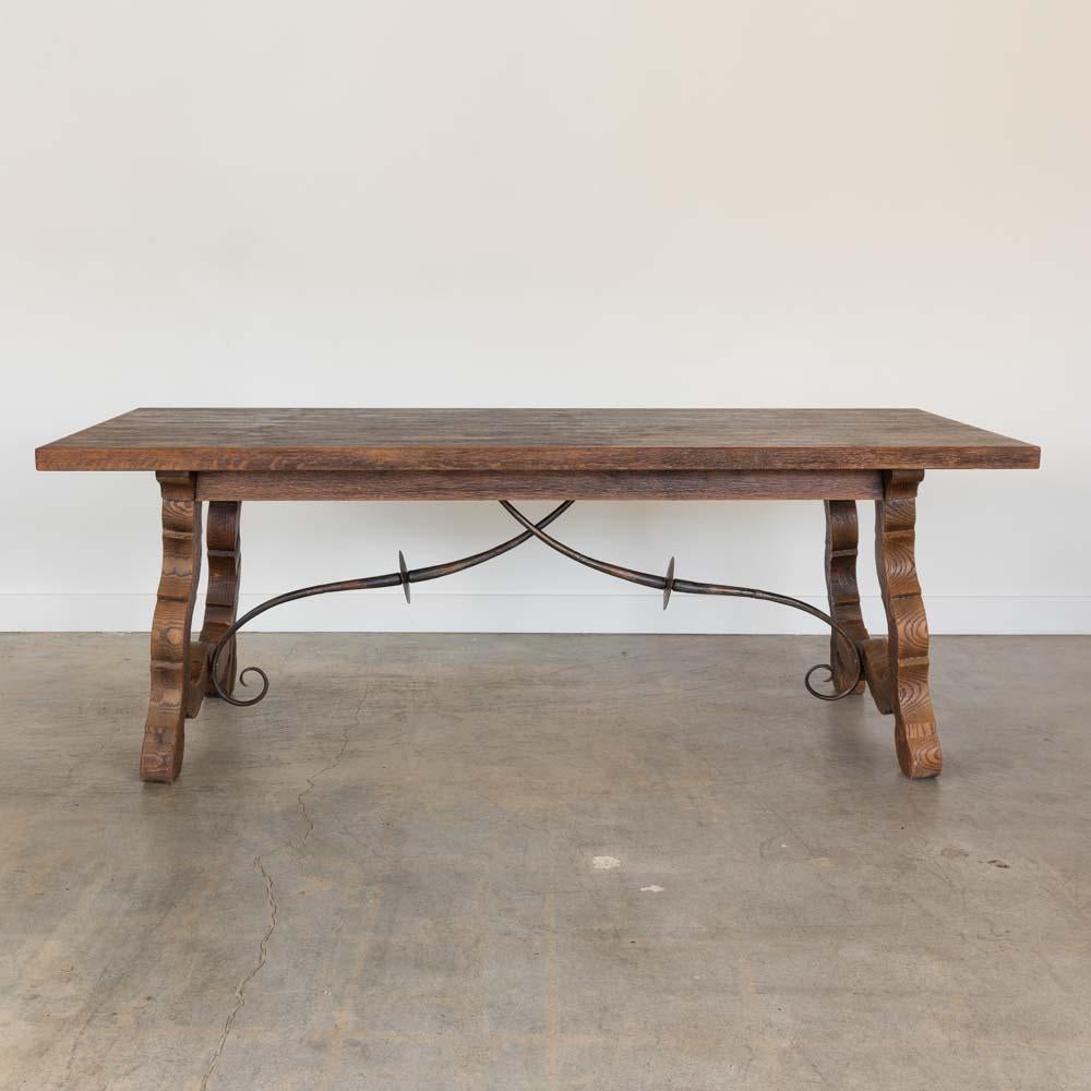 Magnifique table à tréteaux en bois du 19e siècle provenant d'Espagne. Plateau rectangulaire, quatre pieds en bois sculpté et de magnifiques détails en fer forgé en dessous. Chaque pied est orné d'une belle volute. La finition d'origine présente une