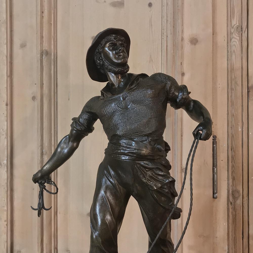 19th century Spelter Statue of Fisherman by sculptor Waagen (1869-1910) shows our ardent seaman standing in the prow of a dory, about to toss his grappling hook aboard his fishing vessel after retrieving the vessel's anchor. The title of the work is