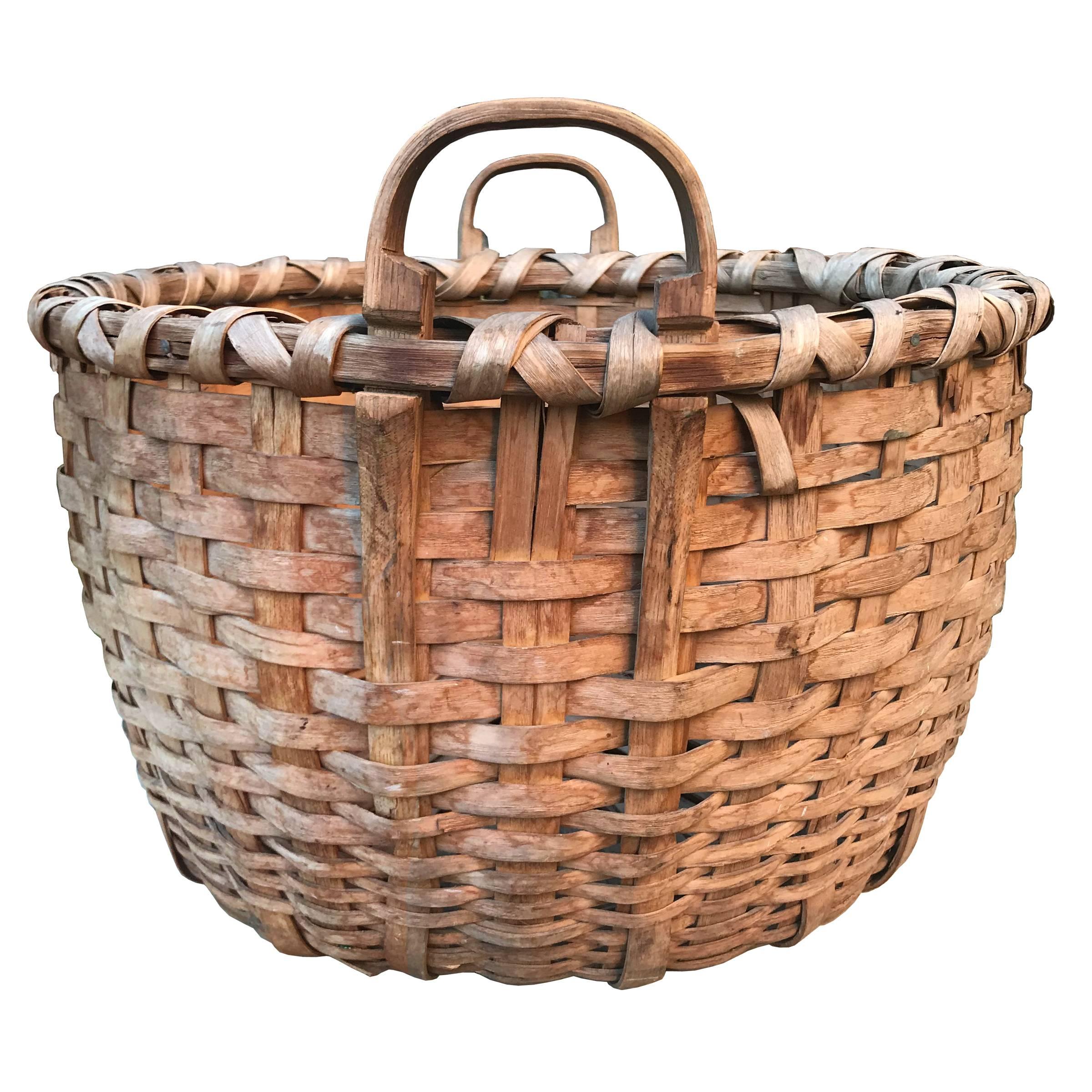 A fantastic 19th century woven splint oak bushel basket with two bentwood handles, double rim, and a nice wide base. Found in New England. Purchased because it's beautiful!