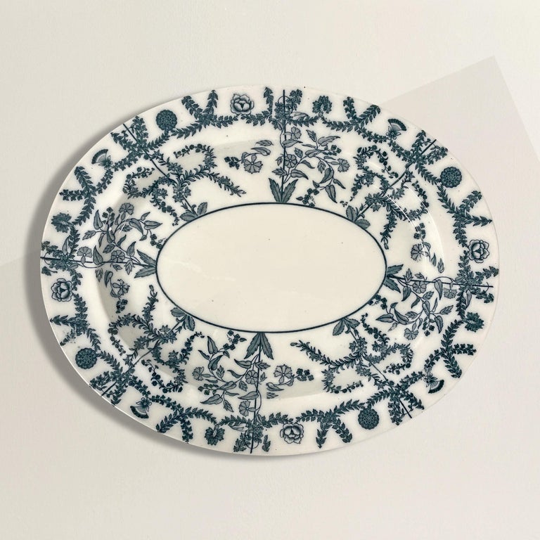 An incredible late 19th century English Spode white porcelain platter with a charming blue transfer floral pattern with roses, leaf festoons, and other flowering vines. The platter is rather deep and would be perfect for serving roasts, chickens, or