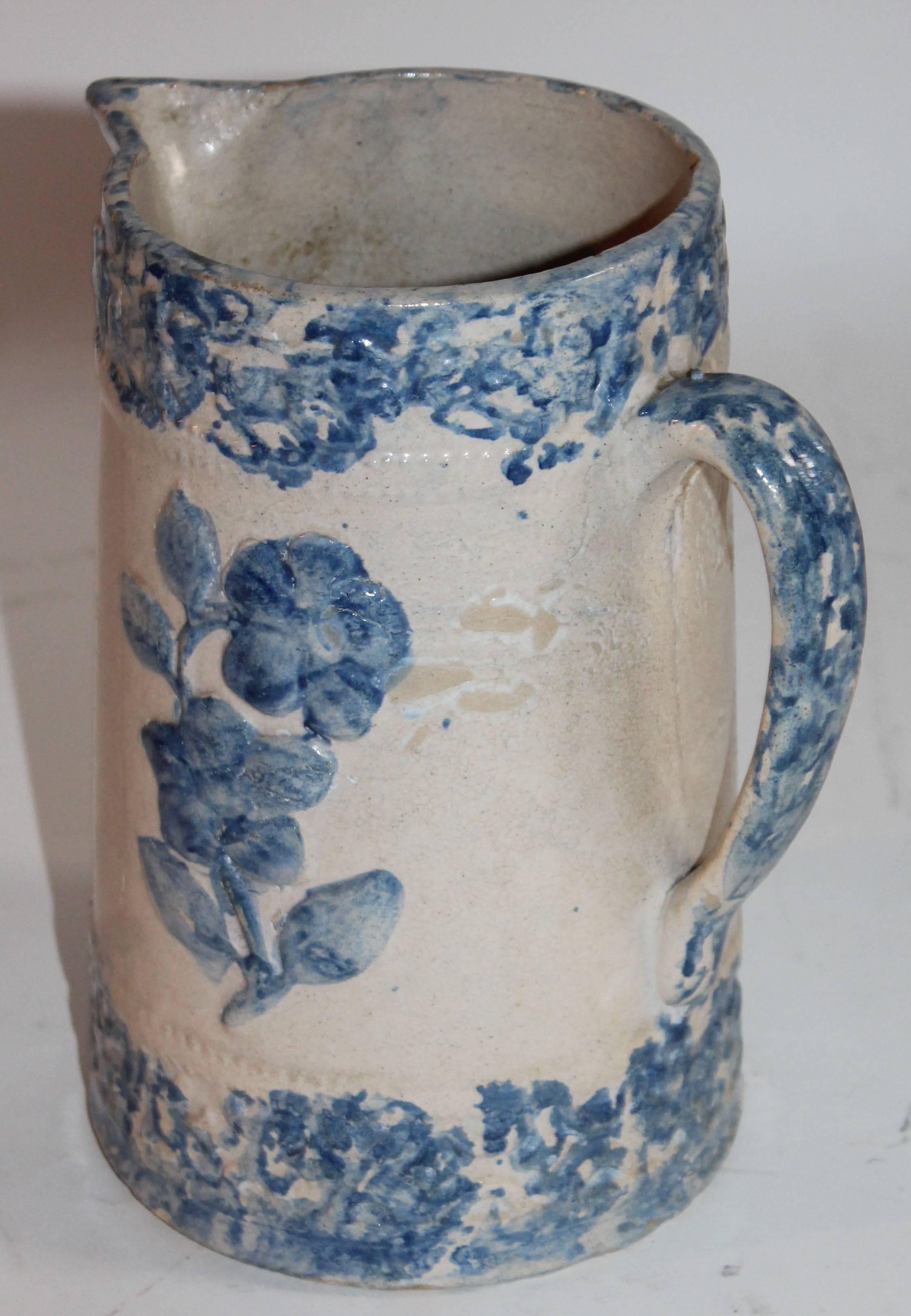 This unusual form spongeware water pitcher is in good condition with minor chips around the inside lip. The floral is embossed on both sides of the pitcher. There are no cracks just age crazing.