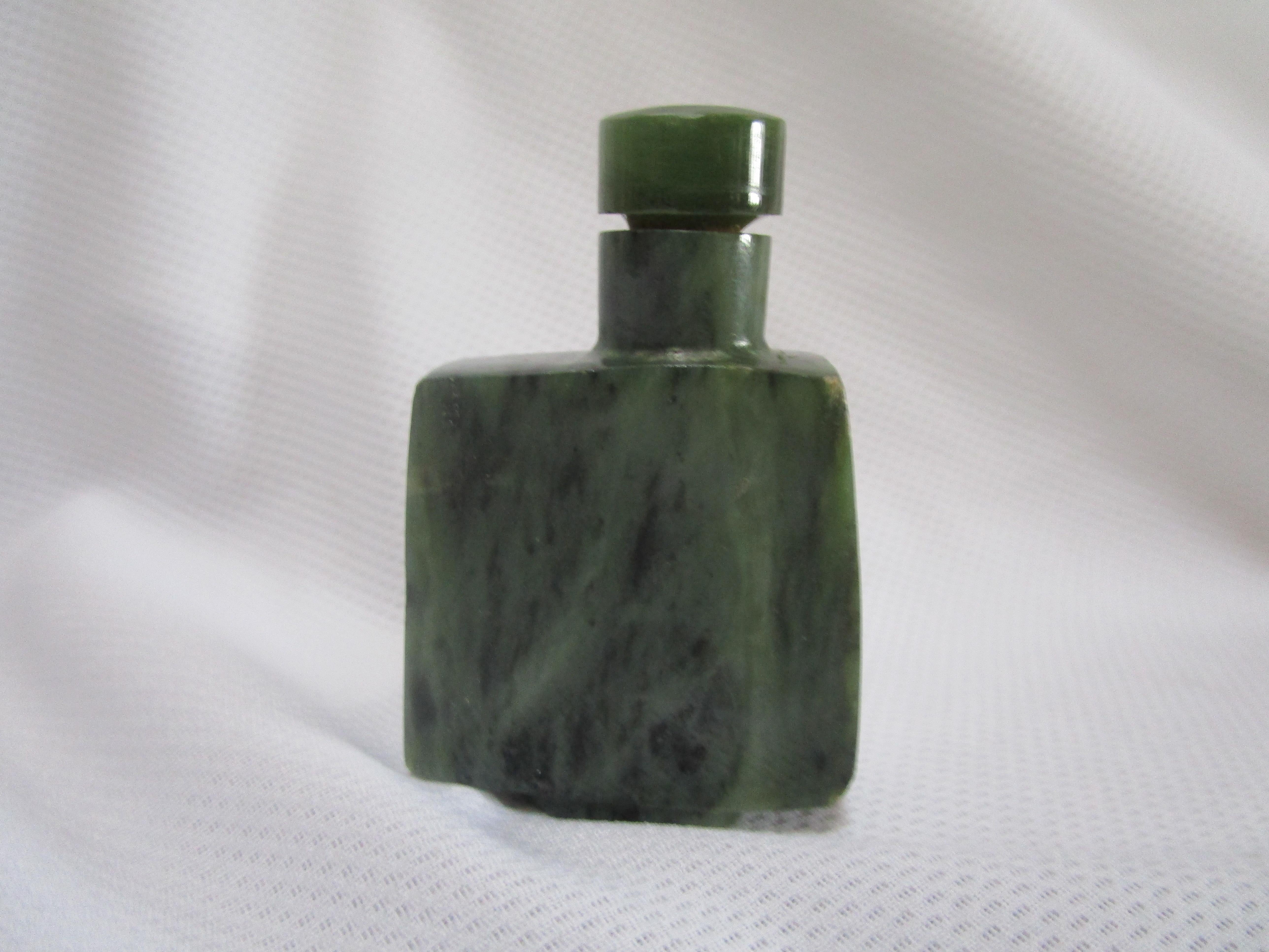 Questa boccetta di giada di spinaci ha un aspetto geometrico con la sua silhouette squadrata e la sporgenza progettata in modo ergonomico per accogliere un dito o un pollice durante l'utilizzo della boccetta.
Si tratta di un pezzo elegante e in