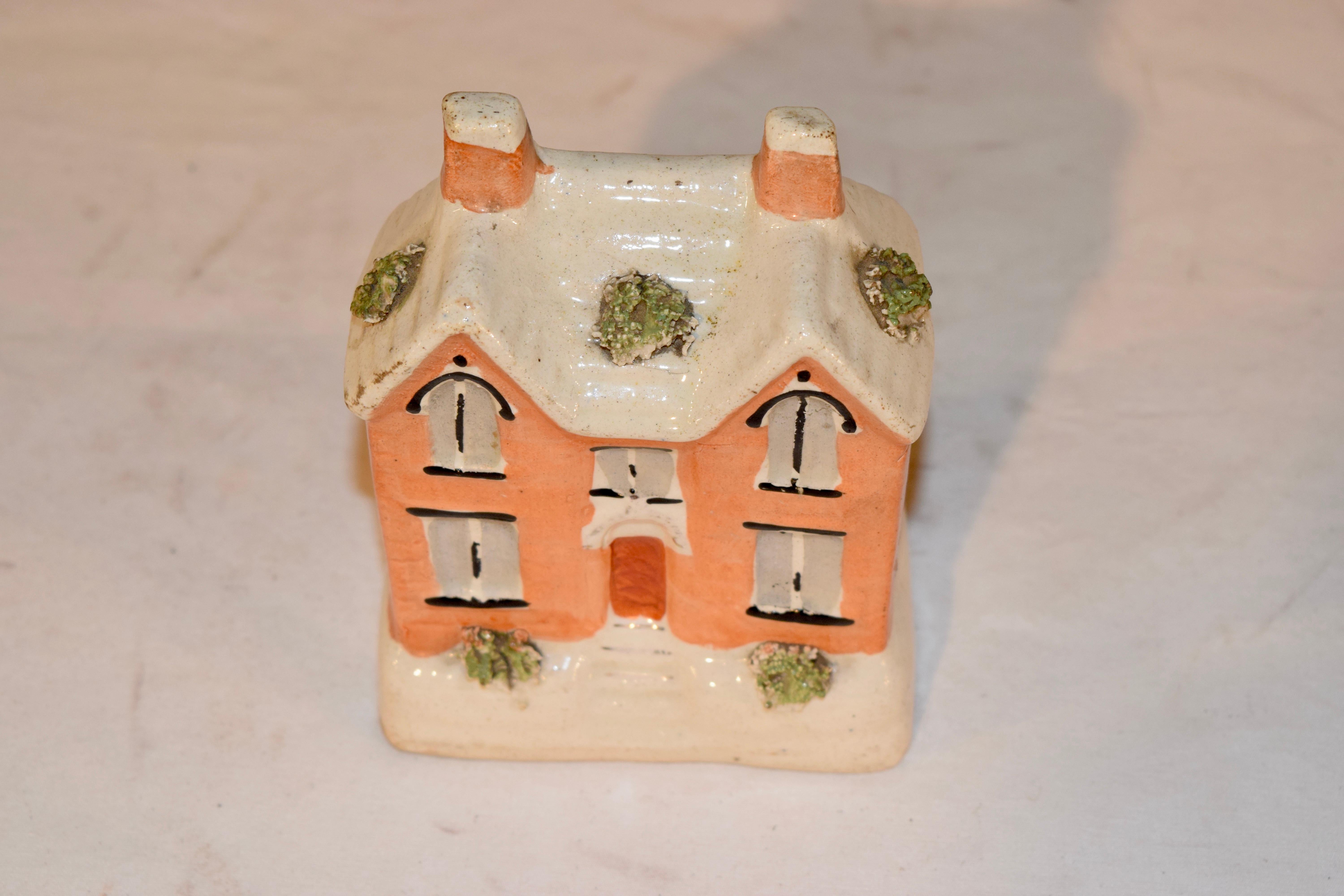 19th century Staffordshire pottery penny bank from England in the form of a cottage with flocked details. The coin slot has a few nicks from age and use.