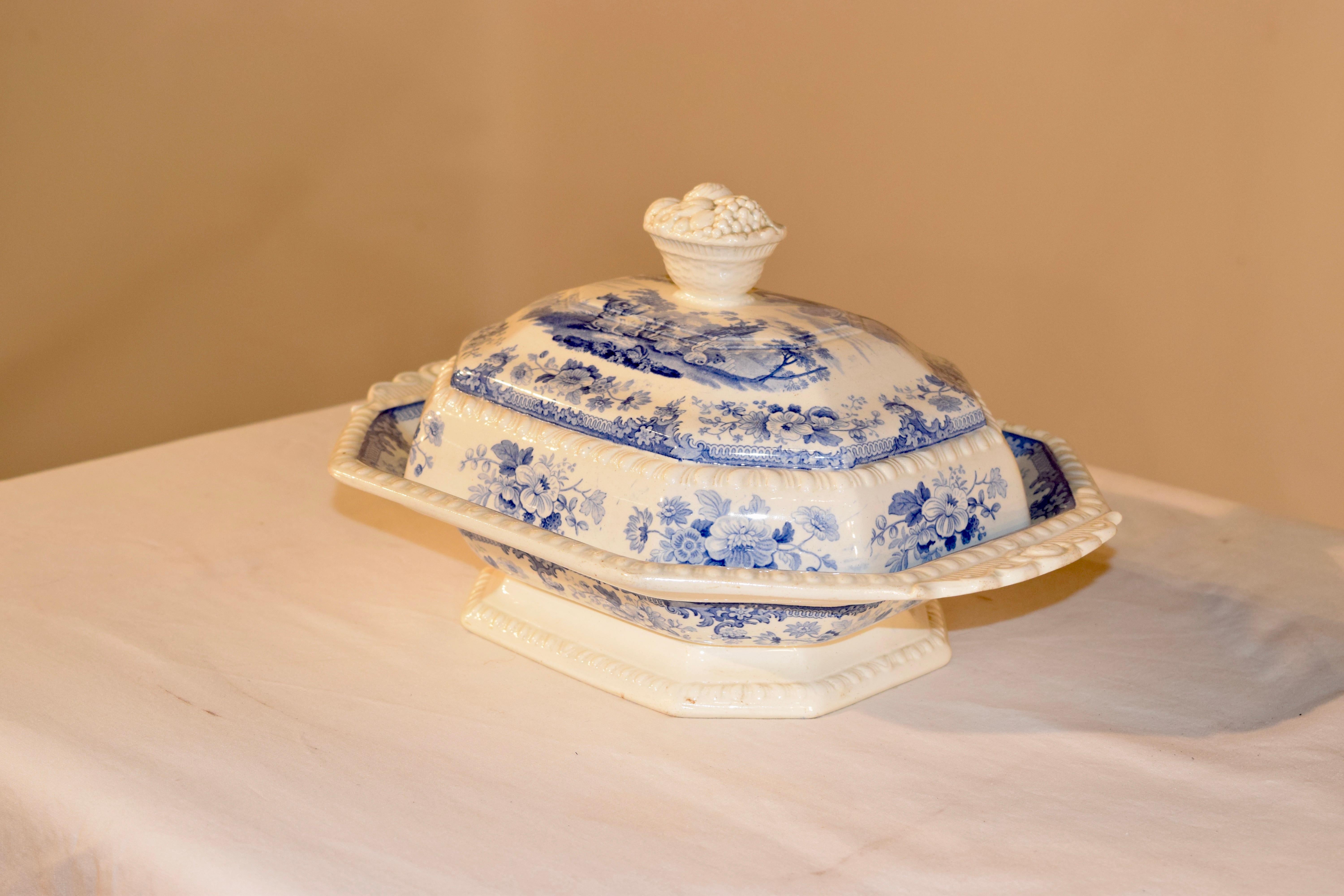 19th century English porcelain covered vegetable dish from the Staffordshire region of England with a fantastic fruit basket molded handle on the top and molded floral handles as well. The transfer pattern is of a wonderful pastoral scene with