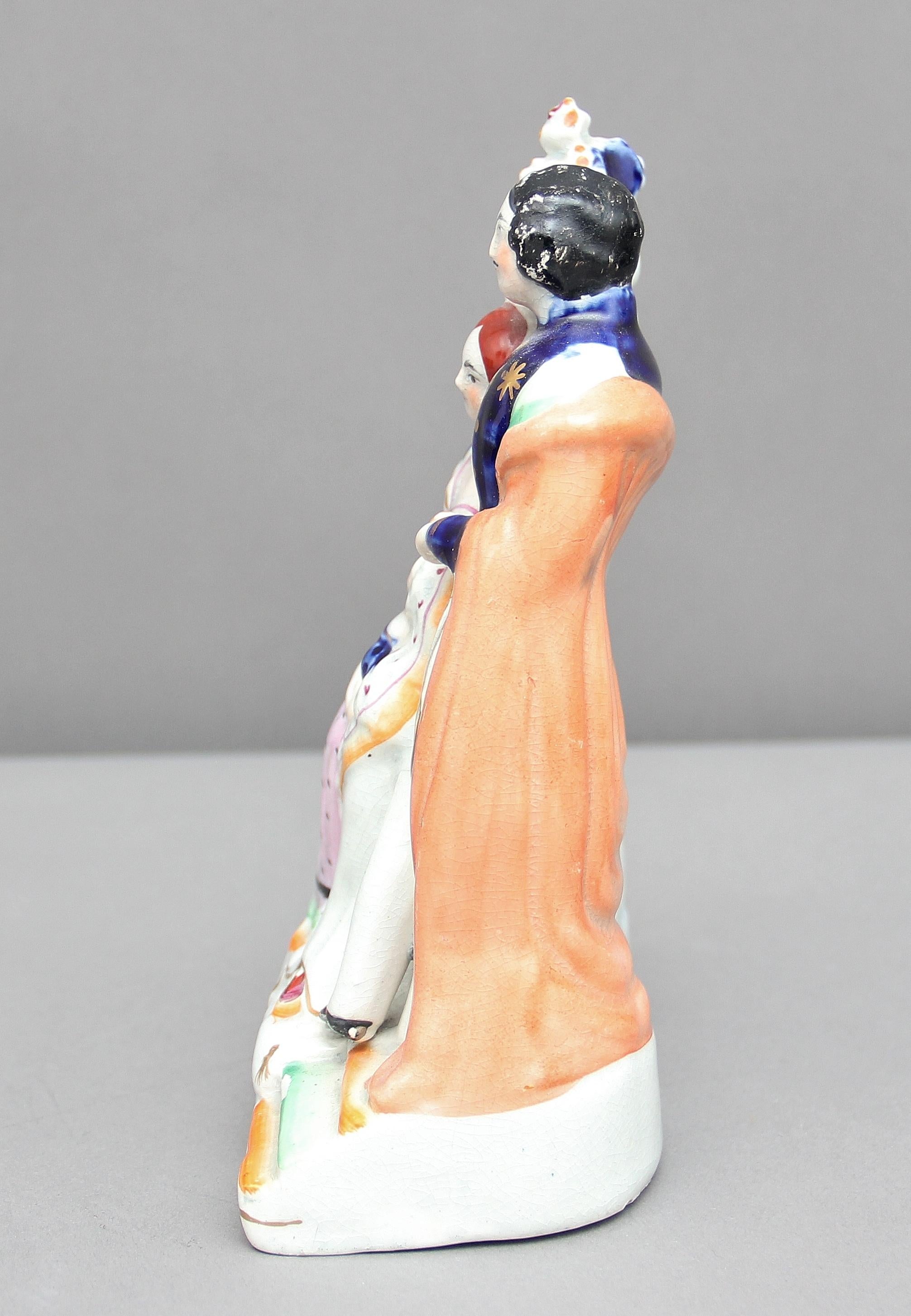 19th century Staffordshire figure group of Queen Victoria and Prince Albert, Queen Victoria is holding a baby. Lovely colors and in very good condition, circa 1840.
 