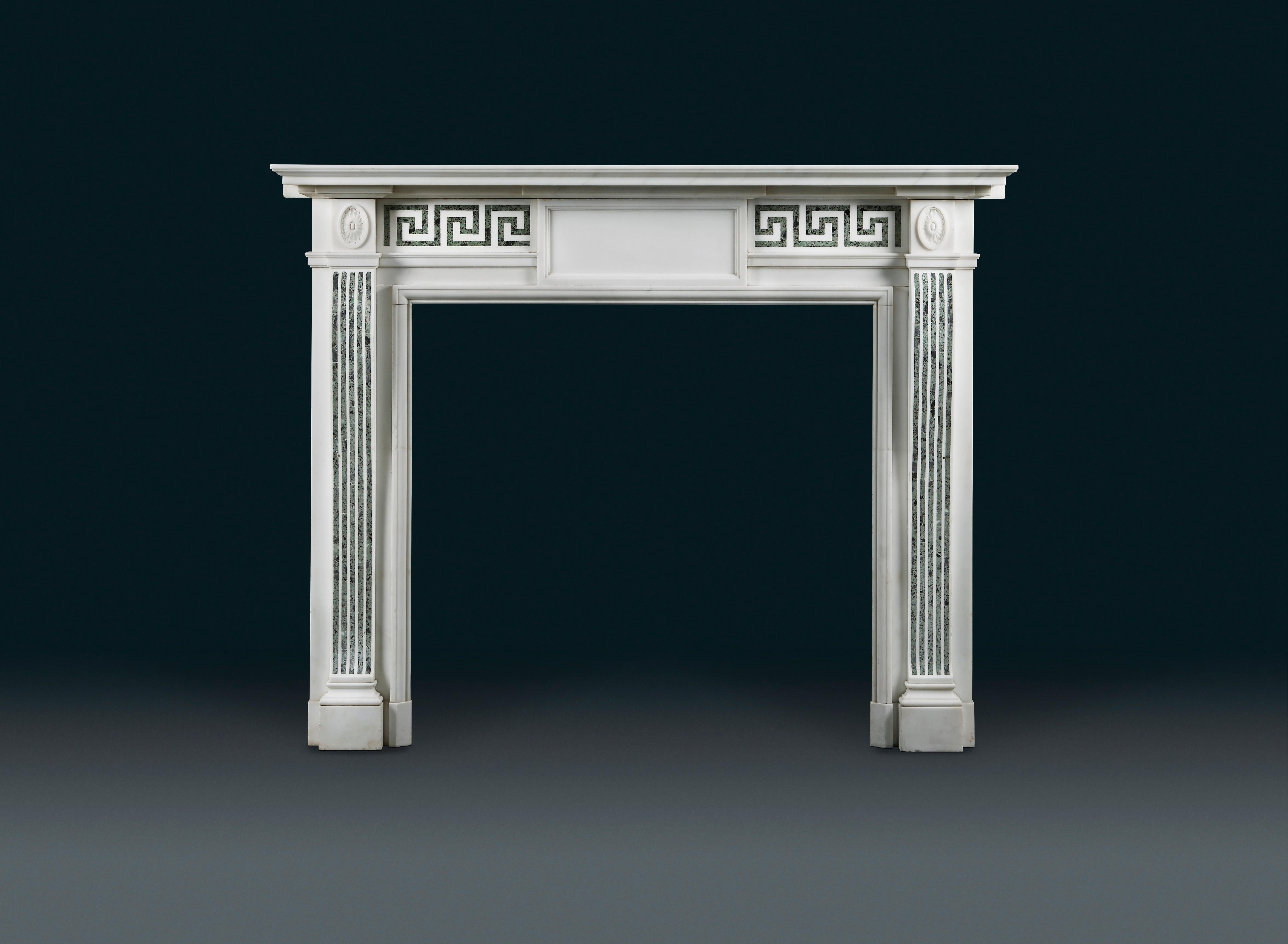 A 19th century statuary and Antico Verde marble fireplace in an earlier neoclassical style. With a tiered and moulded shelf above the double Greek key frieze, centred with a panelled plain centre tablet. The flanking rectangular blockings with oval