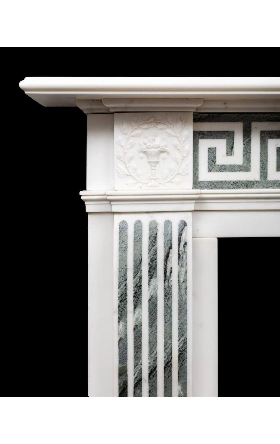 An antique Statuary and Connemara marble fireplace from the late Georgian period.

The white Italian Statuary Carrara marble frieze is inlaid with Irish green Connemara marble forming a continuous Greek key pattern. The flanking square end-blocks