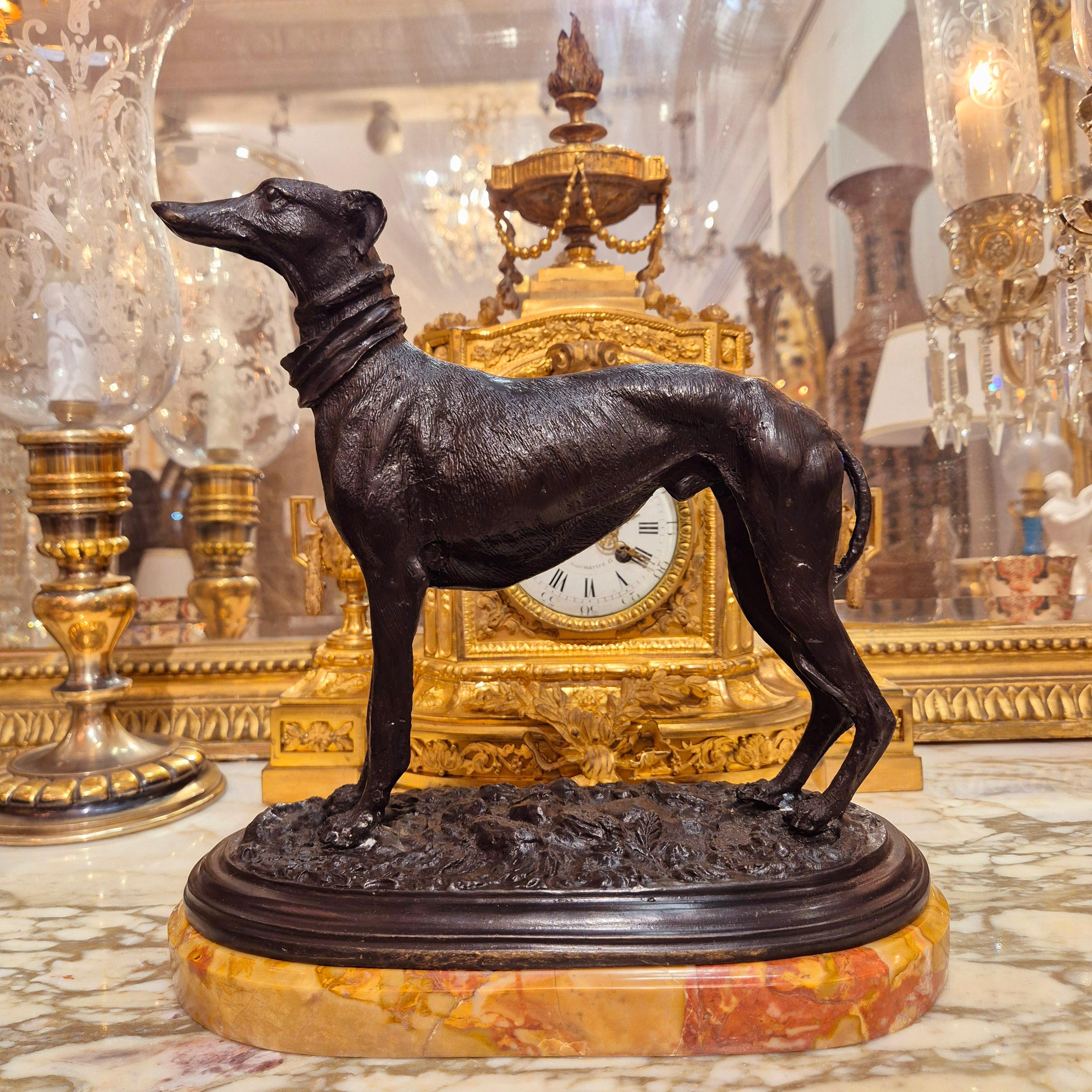 Cette sculpture de lévrier de la fin du XIXe siècle est réalisée en bronze et présente de fins détails de la structure musculaire du chien. 

Le chien se tient debout sur un socle qui imite un terrain accidenté et est monté sur une base en marbre.