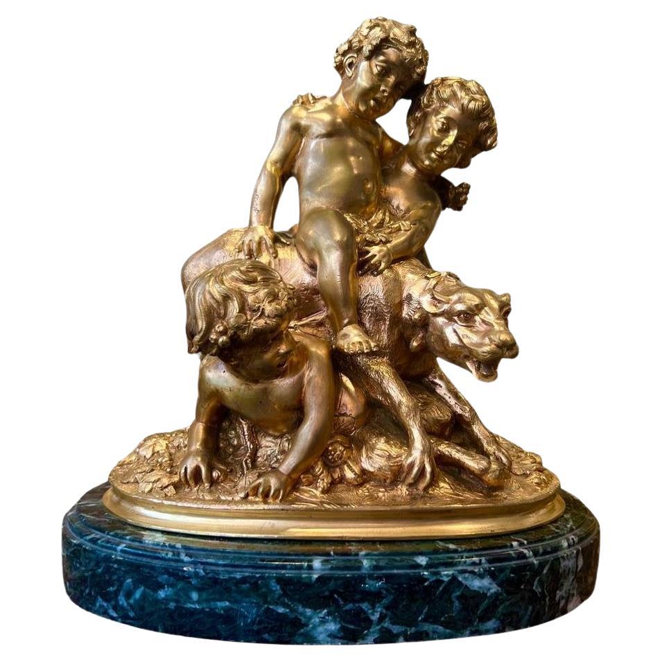 Statue d'enfants jouant avec une lionne en bronze doré du 19e siècle  en vente