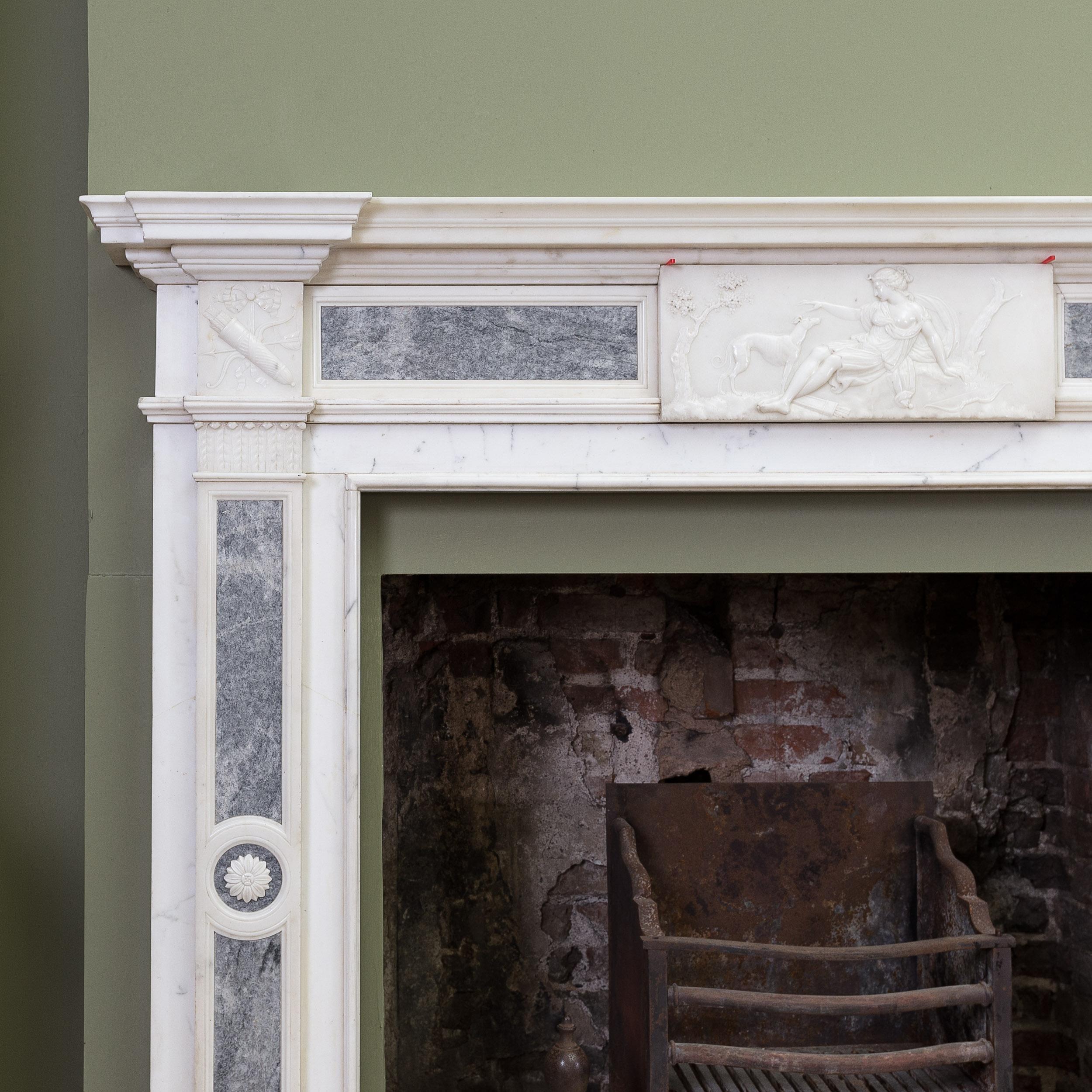 A Nineteenth century Stauary and Marmo Grigio neo-classical fireplace, the invert breakfront shelf above panelled frieze centred by tablet carved in relief depicting Diana the Huntress with her hounds, the corner blocks of ribbon-tied bow, arrow and